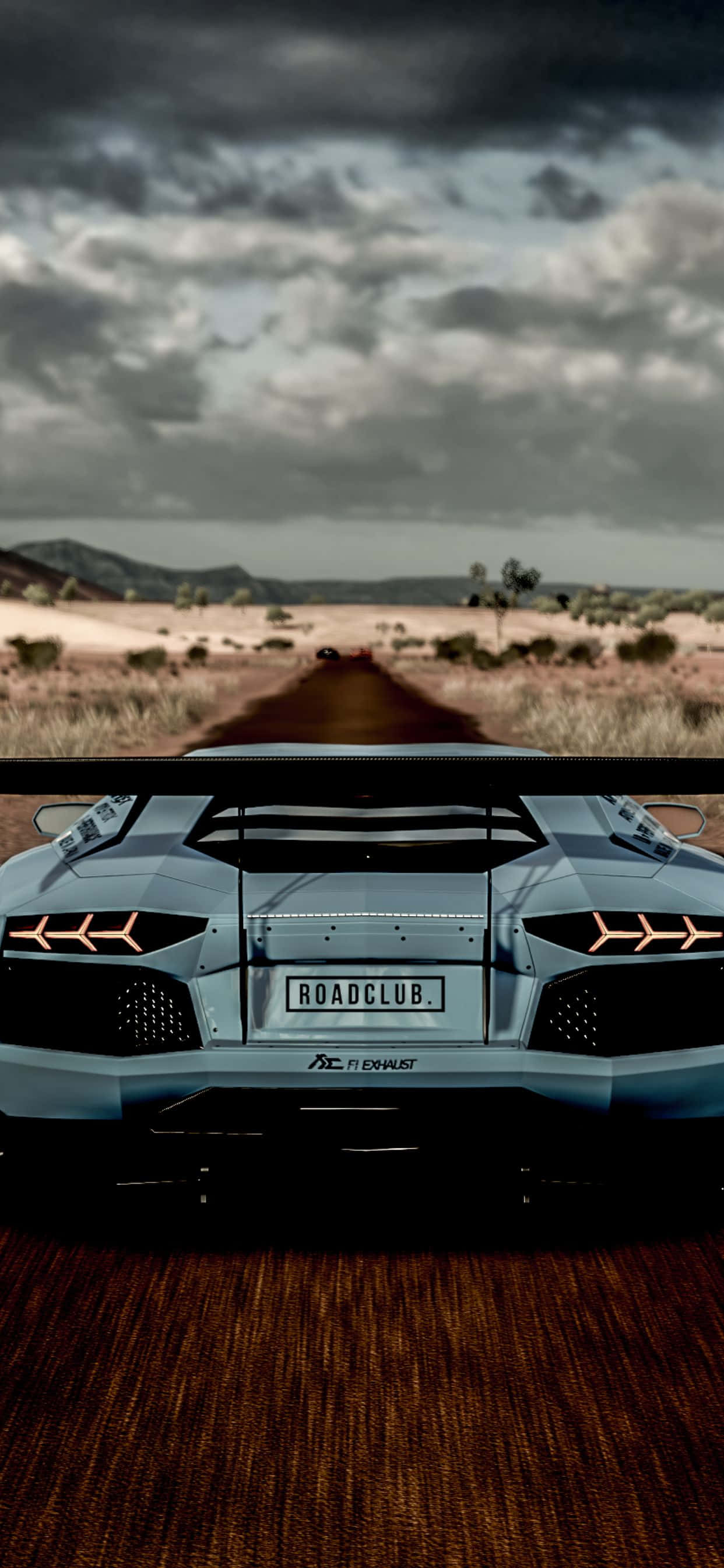 iPhone XS Max Lamborghini Aventador 後視背景 壁紙 — 一輛銀色林寶堅尼Aventador在沙漠公路上，背景是風暴天空和遠山，從後方觀看。