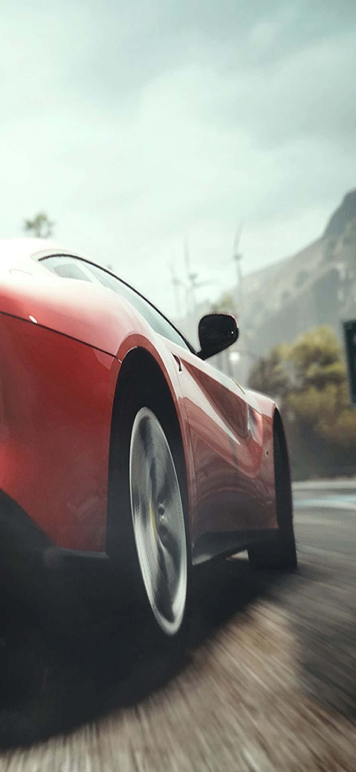 iPhone XS Max 《Need for Speed Heat》紅色跑車背景 壁紙 — 一輛鮮紅色跑車沿著山路疾馳，背景是模糊的動感和霧氣繚繞的山峰。