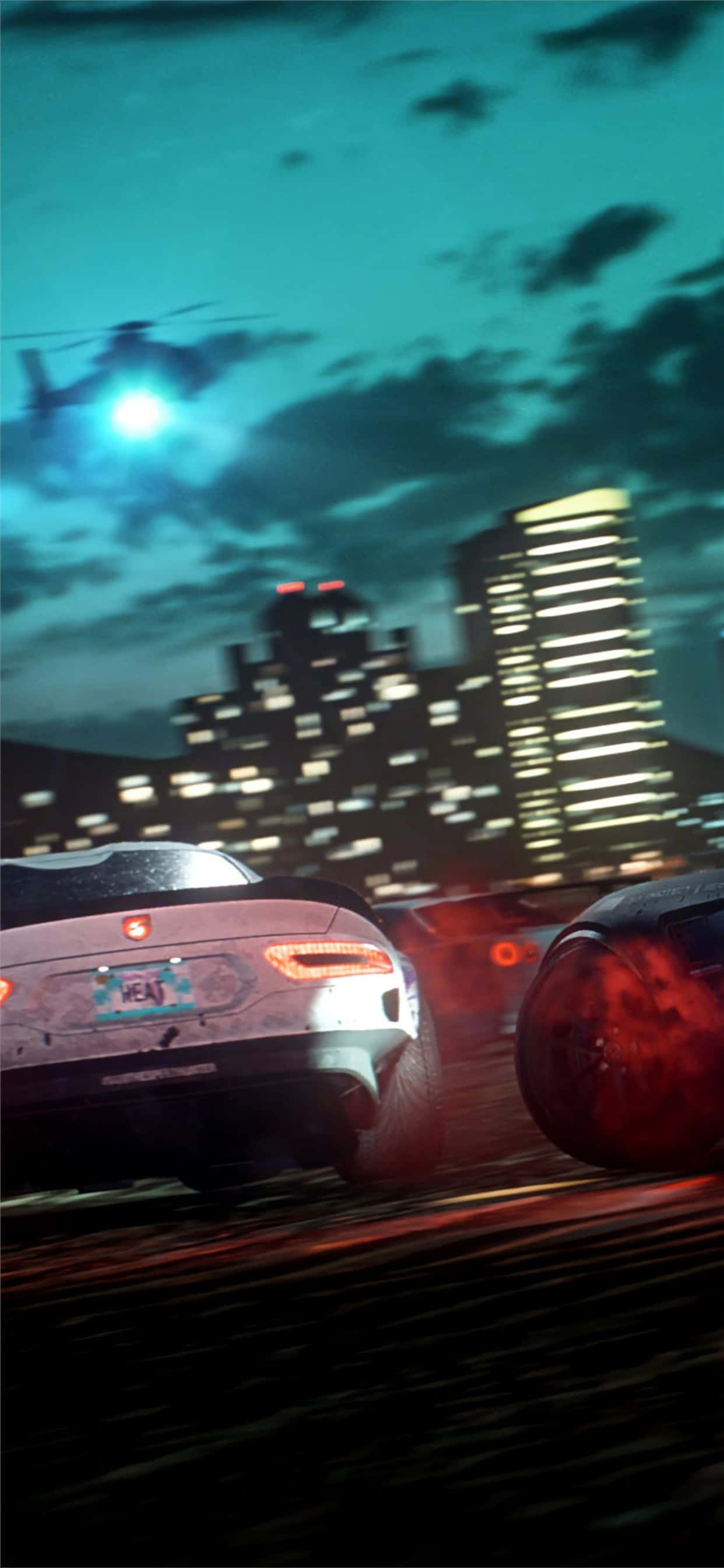 iPhone XS Max《Need for Speed Heat》城市風景背景 壁紙 — 兩輛跑車在夜晚穿過霓虹燈照亮嘅城市，一架直升機喺發光嘅摩天大樓上空盤旋。