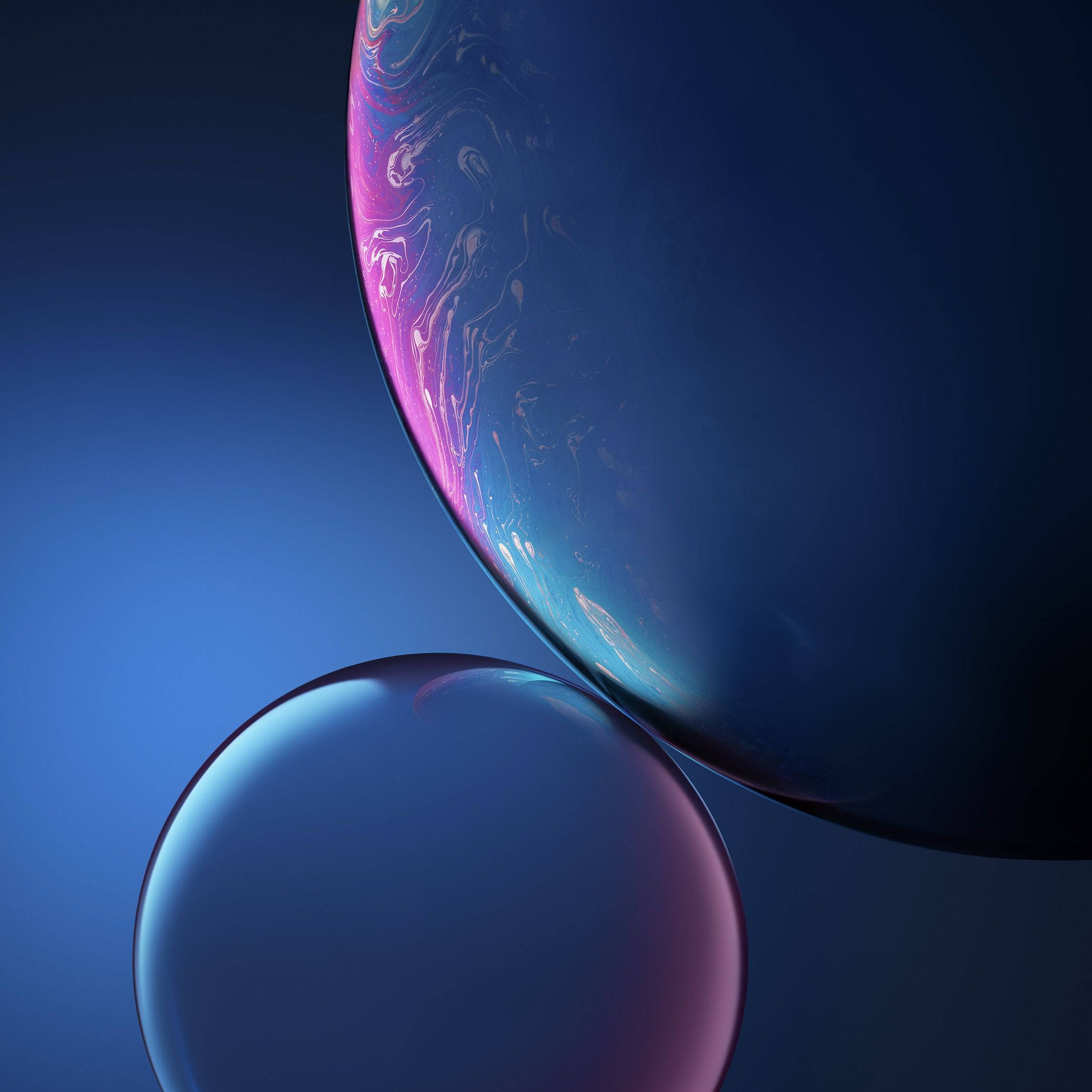 iPhone XS Max OLED 藍色星球藝術 壁紙 — 兩個彩虹色肥皂泡漂浮在深藍色漸變背景上，帶有旋轉的粉紅色和青色亮點。