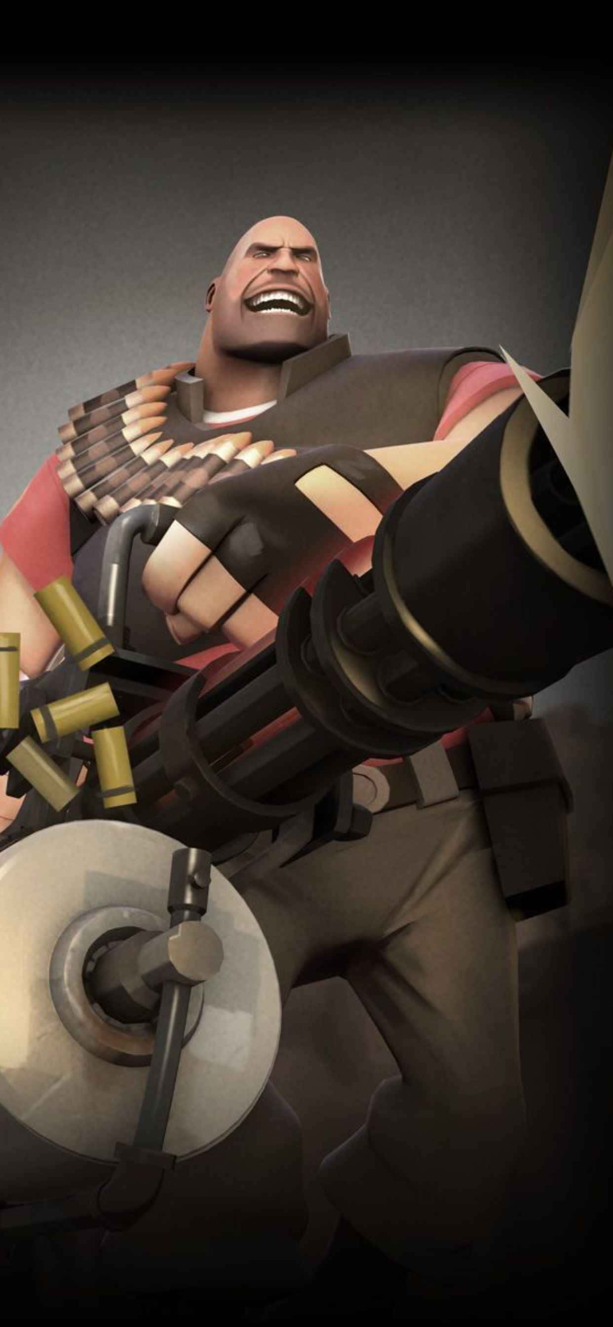 重型機槍 iPhone Xs Max 《Team Fortress 2》背景 壁紙 — 一個肌肉發達的光頭男子帶著兇猛的笑容揮舞著一把大型機槍，用過的彈殼在他周圍飛舞。