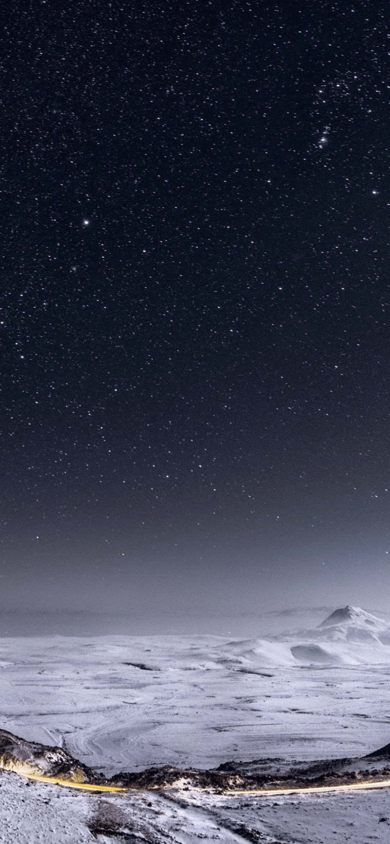 iPhone XS Max 星空雪山壁紙 壁紙 — 星空夜空拱形覆蓋在積雪的山脈上，一條發光的道路蜿蜒穿過前景。