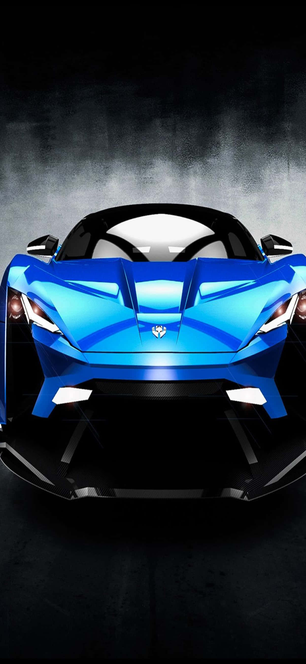 iPhone XS Max 賽車主題藍色 W Motors Lykan HyperSport 背景 壁紙 — 一輛時尚的藍色跑車，帶有發光的前燈，在黑暗煙霧繚繞的背景中直視前方。