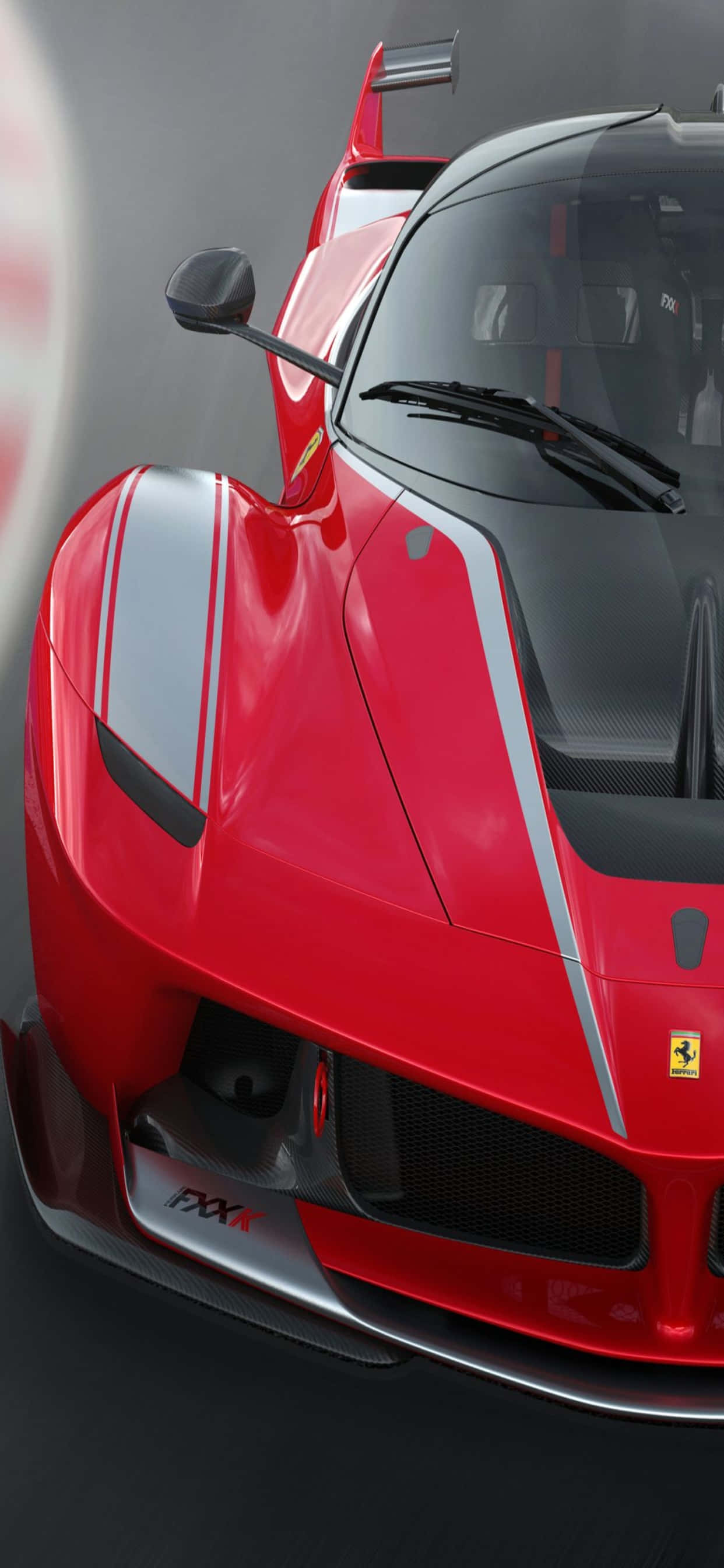 iPhone XS Max 賽車主題紅色 Ferrari FXX-K 背景 壁紙 — 紅色法拉利FXX K超級跑車的特寫，帶有銀色條紋和碳纖維細節，背景為深色工作室。