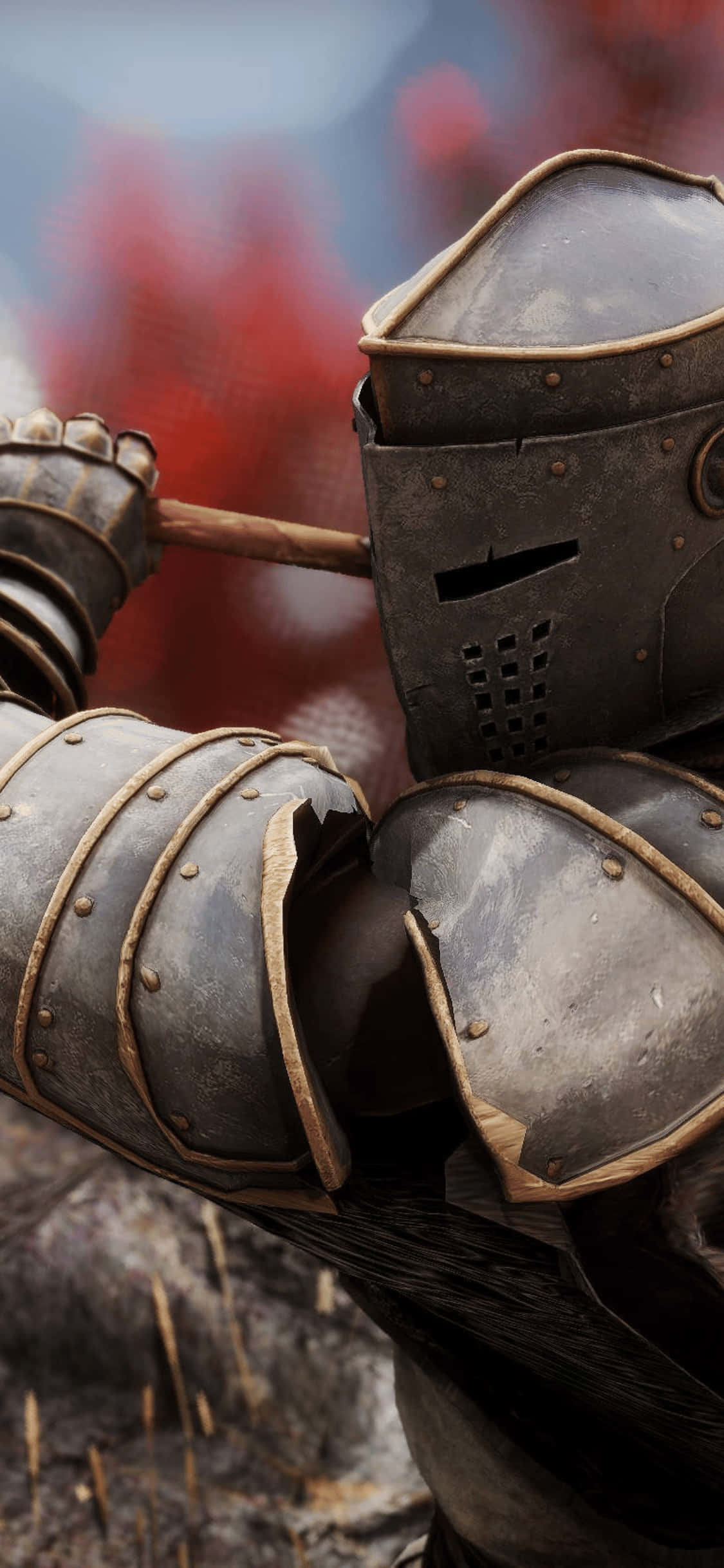 iPhone XS Mordhau 戰士模糊背景 壁紙 — 近距離拍攝身穿精細金屬盔甲的騎士，手持木杖，背景是模糊的火焰紅色。
