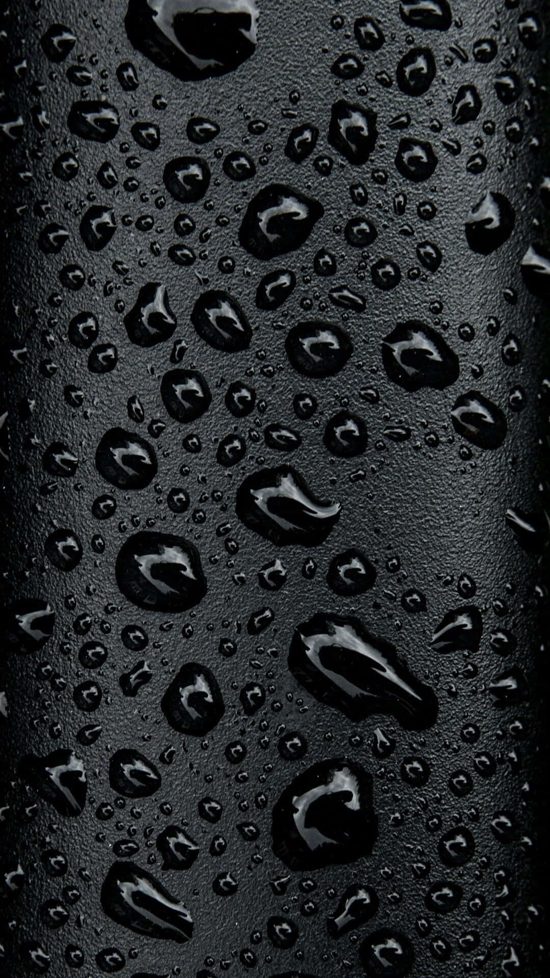 水滴 iPhone XS OLED 背景 壁紙 — 閃亮的水滴依附在啞光黑色表面上，營造出帶有反射高光的陰鬱抽象紋理。