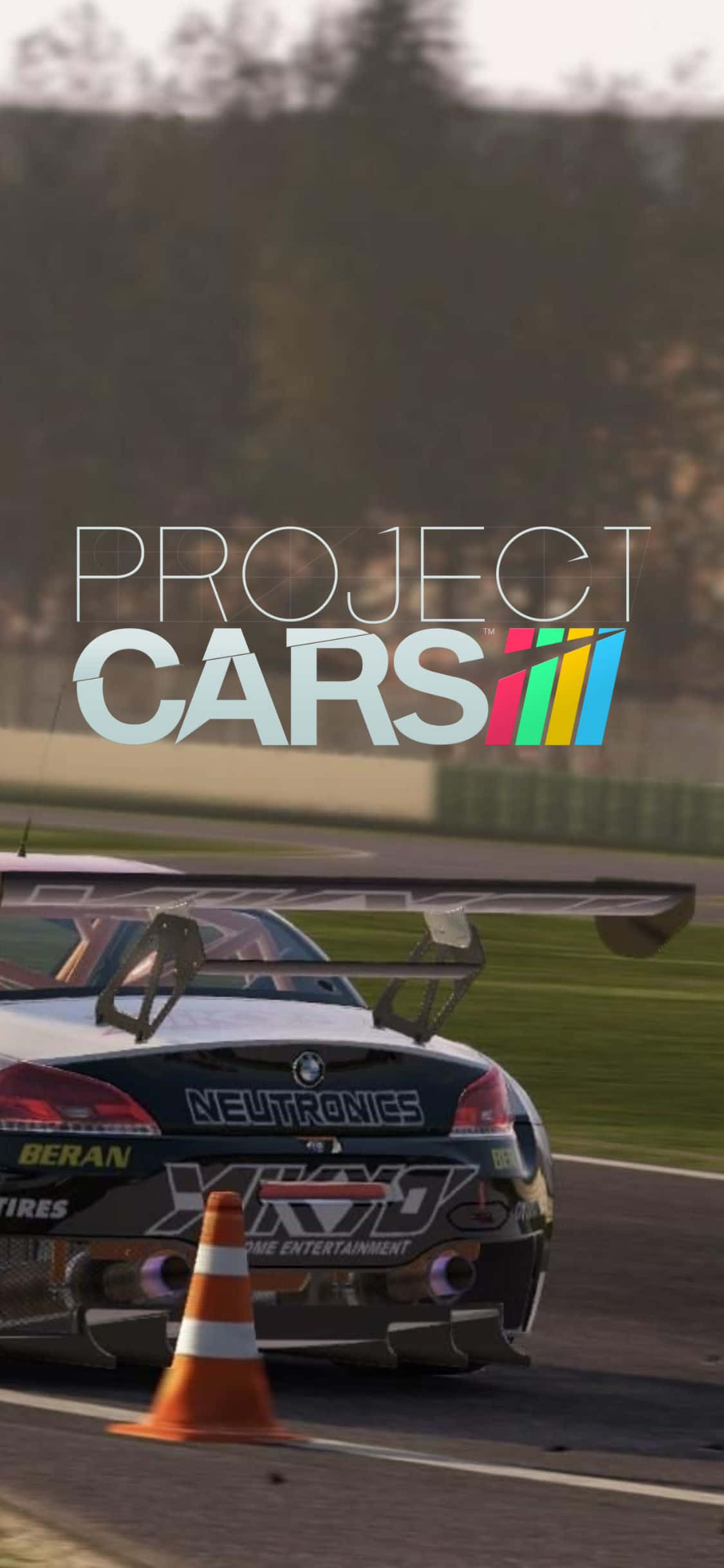 iPhone XS Project Cars — 飛馳的風格與速度 壁紙 — 一輛帶有大型後翼的賽車在賽道上高速駛過一個橙色錐體，並疊加了'Project Cars'標誌。