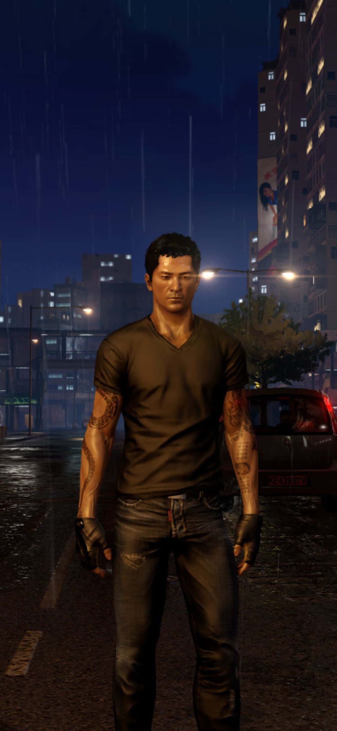 iPhone XS《Sleeping Dogs》魏閔V領雨中背景 壁紙 — 一個有紋身的男人在夜晚雨濕的街道上，站在發光的街燈下，背景有建築物和一輛汽車。