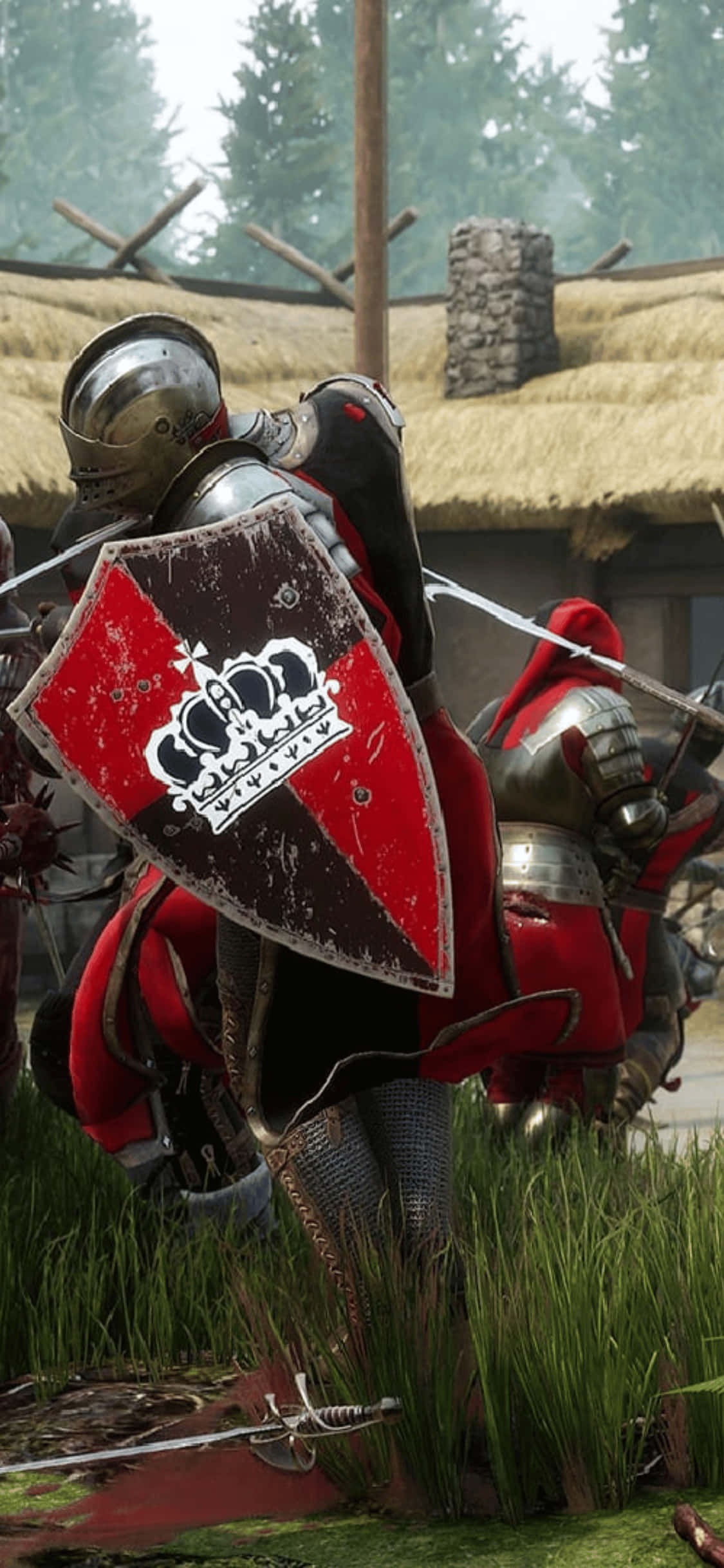 iPhone XS 上的 Mordhau 精彩戰鬥場景 壁紙 — 一位身穿紅色和銀色盔甲的騎士，站在茅草屋頂建築附近的高草中，手持帶有皇冠徽章的盾牌。