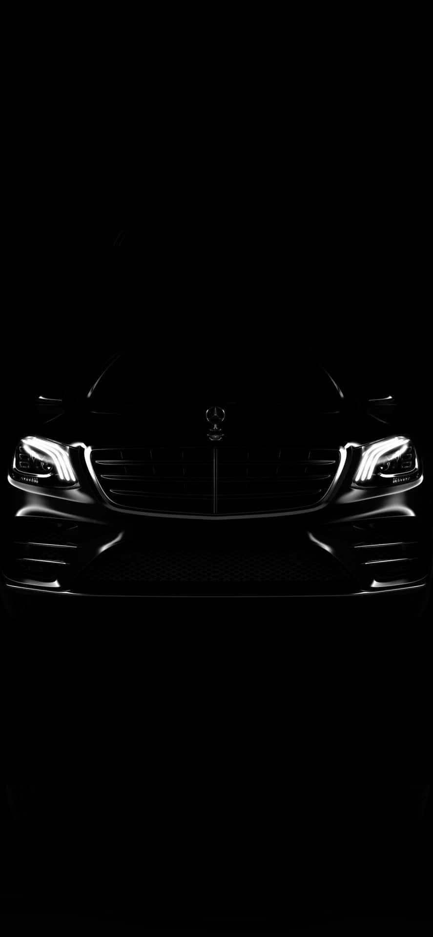 在完全黑暗中發光的豪華車車頭燈和格柵。