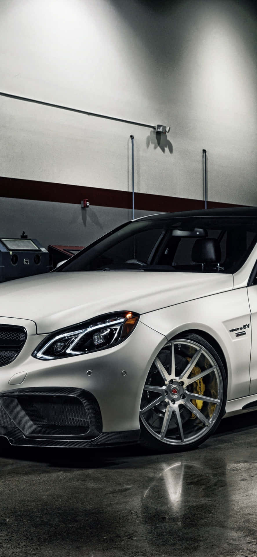 車庫中的銀色 Mercedes-AMG 跑車，配備金色制動器。