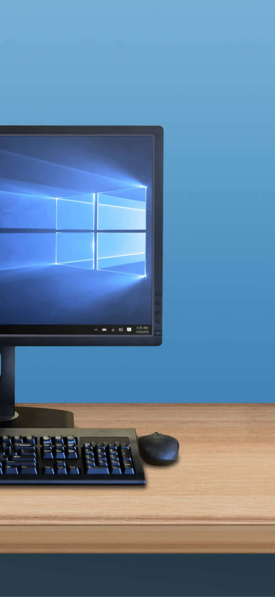 桌上帶有Windows 10標誌的電腦顯示器，配有鍵盤和滑鼠。
