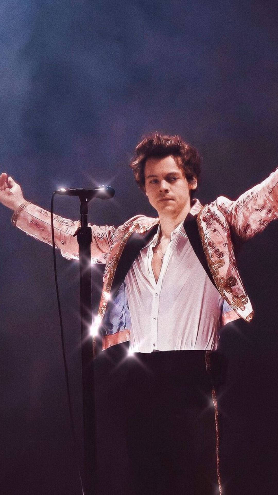 Harry Styles 在明亮的舞台燈光下張開雙臂表演。
