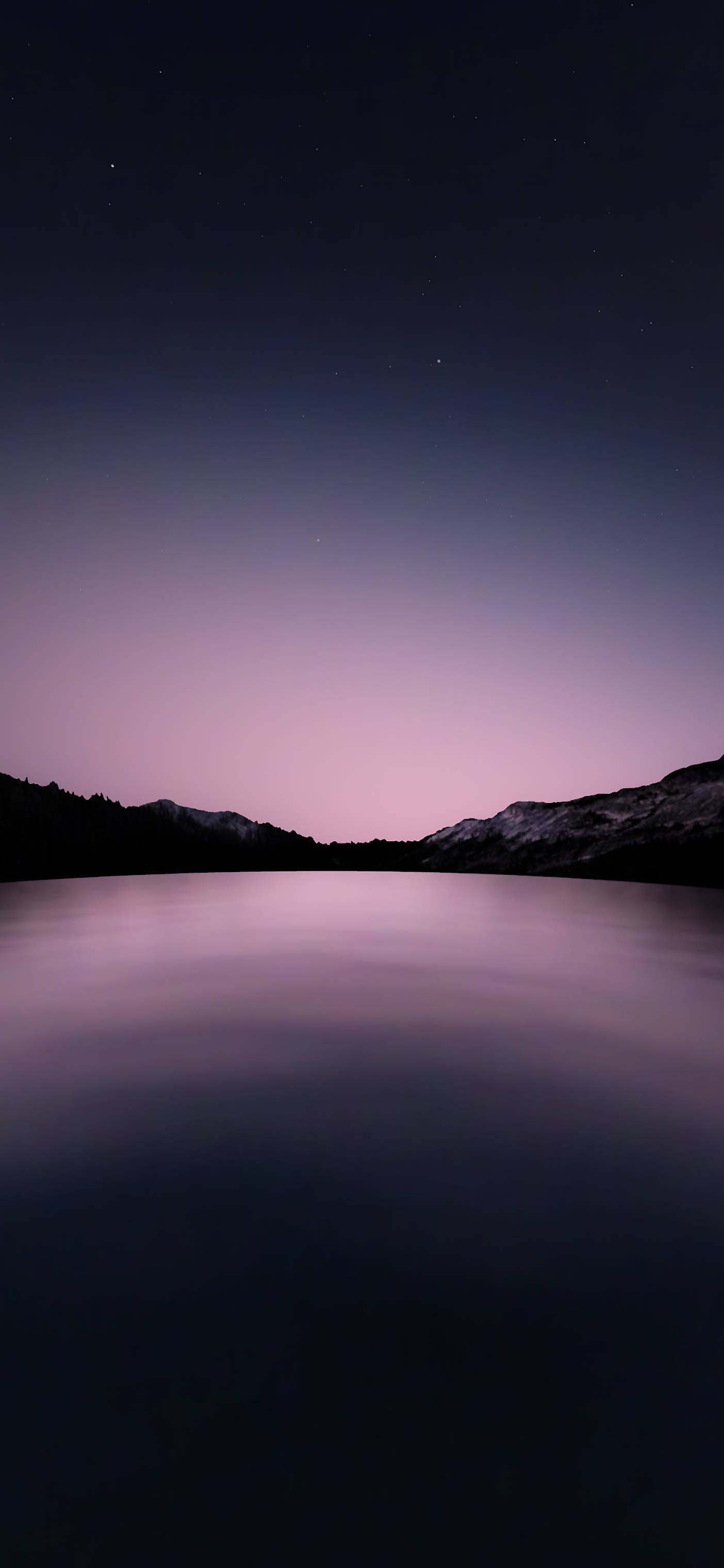 iPhone 加州紫色天空湖景 壁紙 — 一個繁星點點的夜空，帶有紫色漸變，倒映在一個被黑暗山脈輪廓環繞的平靜湖泊上。