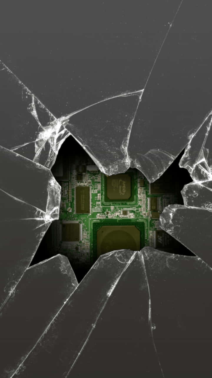 iPhone 屏幕大裂縫惡作劇 壁紙 — 破碎的玻璃表面下方顯露出綠色電路板，呈現出鮮明的數位科技美學。