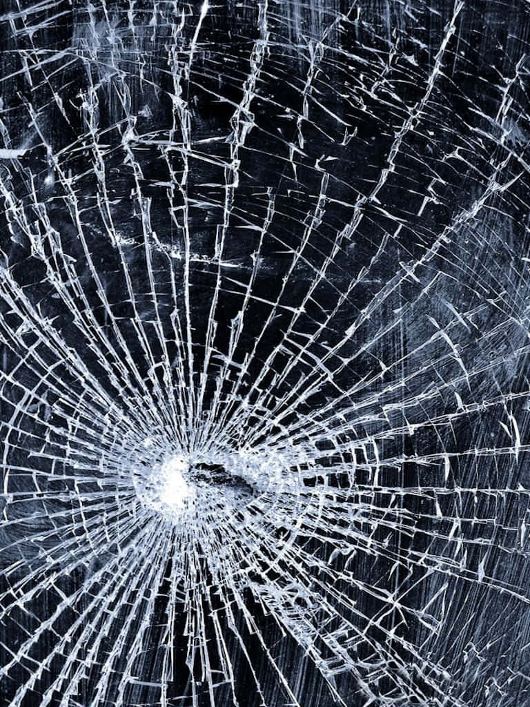 iPhone 屏幕裂痕的視覺欺騙效果 壁紙 — 特寫破碎玻璃，中央撞擊點向四周放射裂紋，背景為深色。