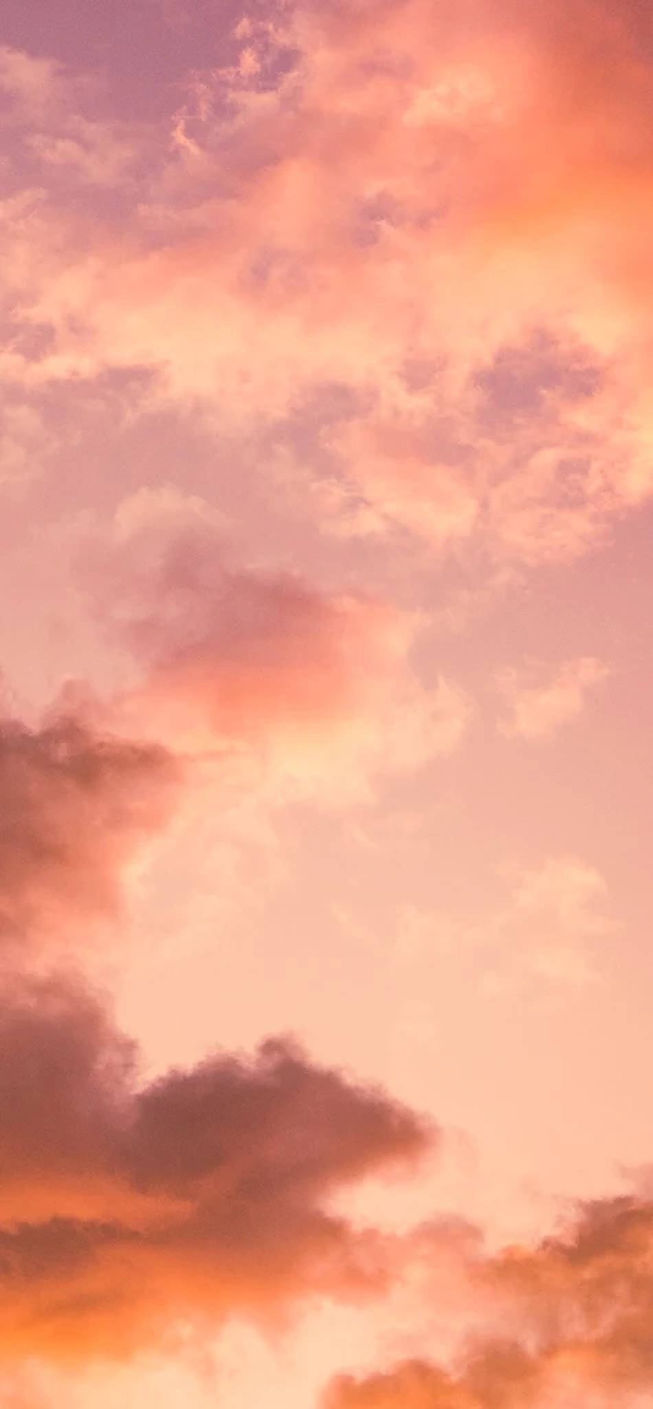 iPhone 美學天空 壁紙 — 寧靜的天空塗上柔和蜜桃和珊瑚色調，夕陽下薄雲發光。