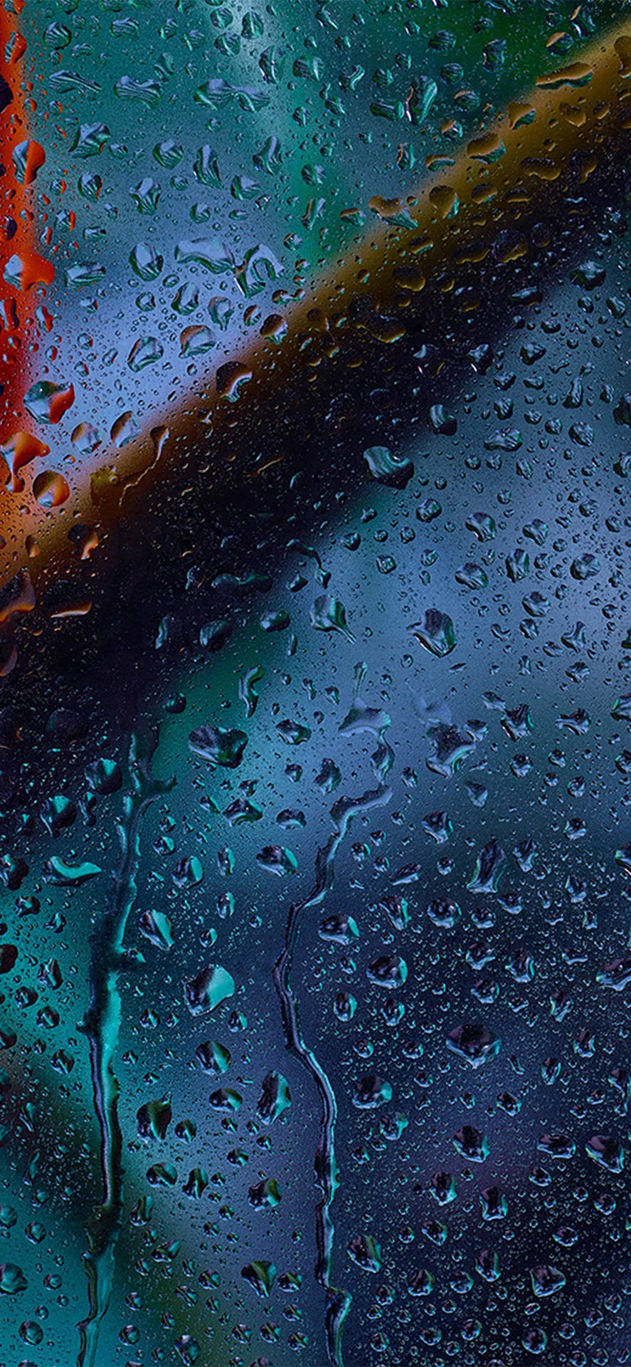 玻璃上的雨滴與模糊的藍色和紅色霓虹燈光