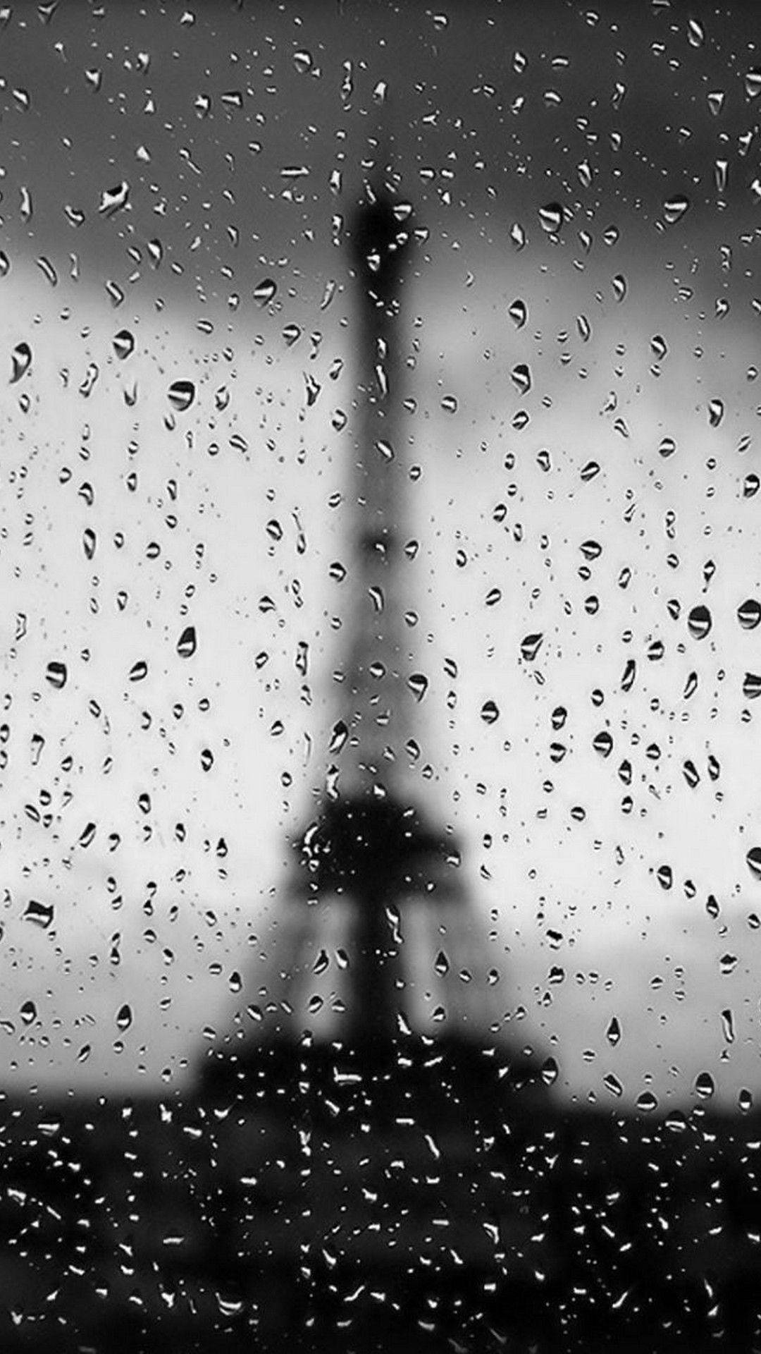 玻璃上的雨滴與模糊的艾菲爾鐵塔背景