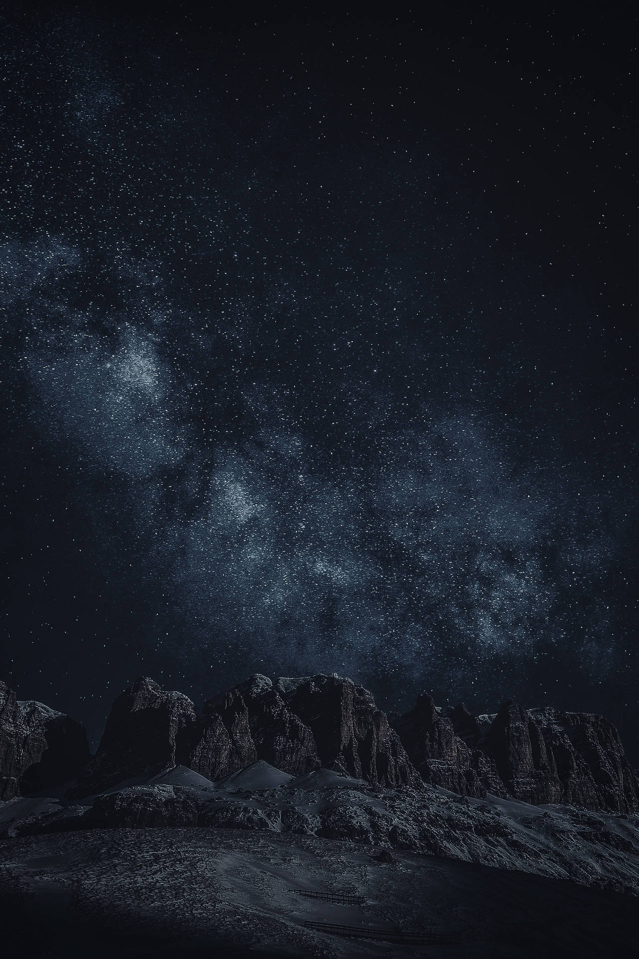 在繁星點點的夜空下，黑暗崎嶇的山脈，銀河清晰可見。