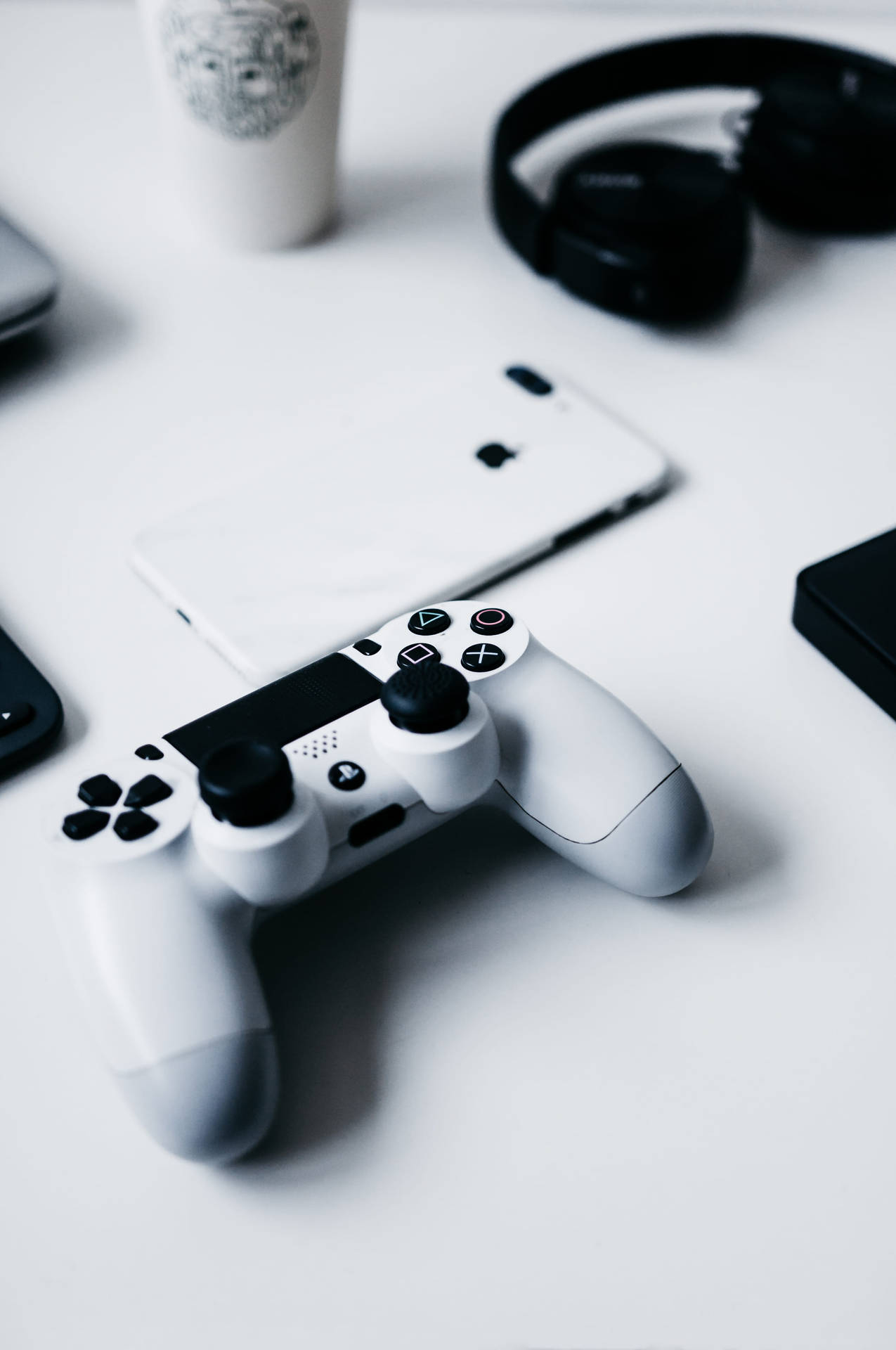 乾淨桌子上的白色遊戲手掣，附有電話和耳機。