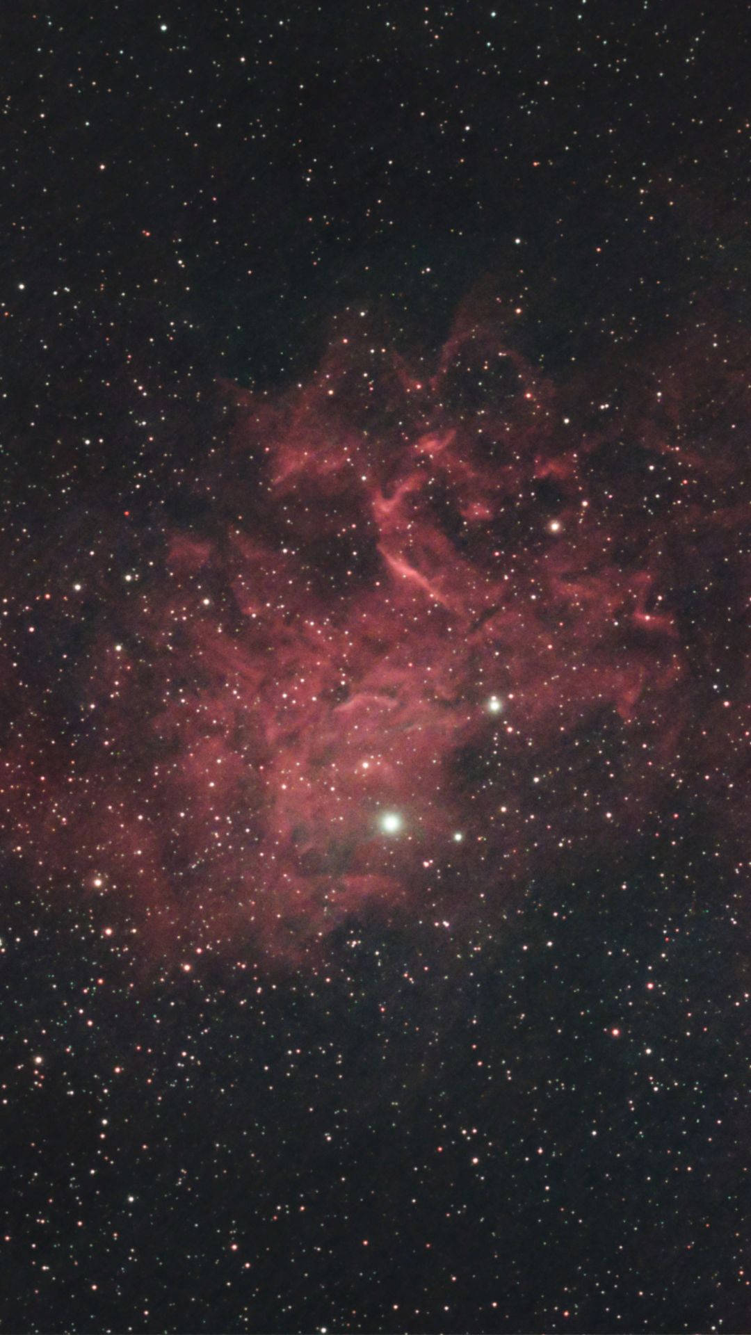 夜空中被星星包圍的發光紅色星雲。
