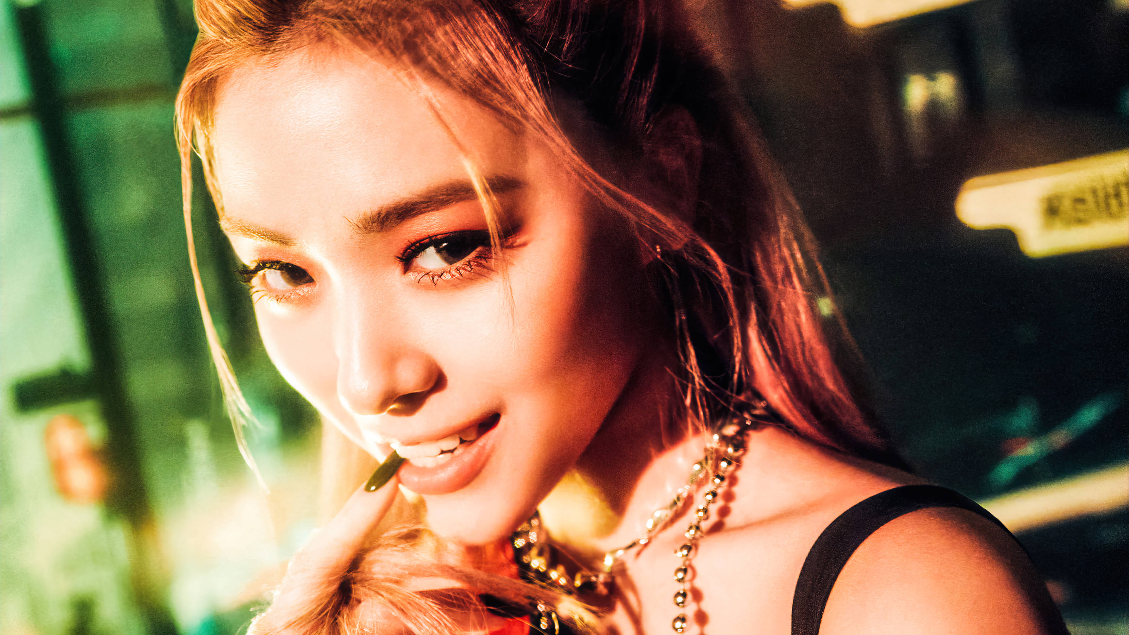 酷女孩 ITZY Ryujin 壁紙 — 一位金髮濃妝的迷人女性在霓虹燈閃爍的都市夜景中微笑著拿著香煙。