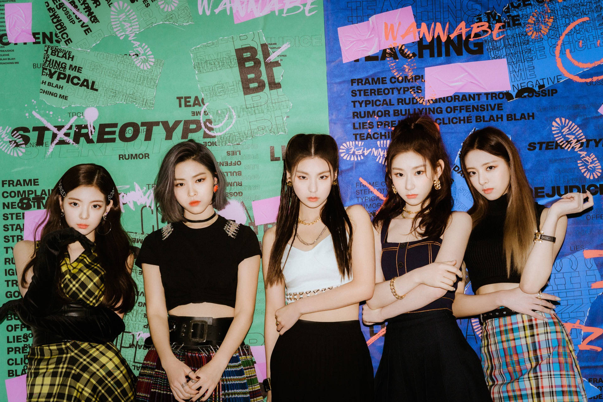 ITZY《WANNABE》海報 壁紙 — 五位年輕女性自信地擺姿勢，背景是一面佈滿塗鴉的牆，上面寫著「刻板印象」和「想成為」等字樣。