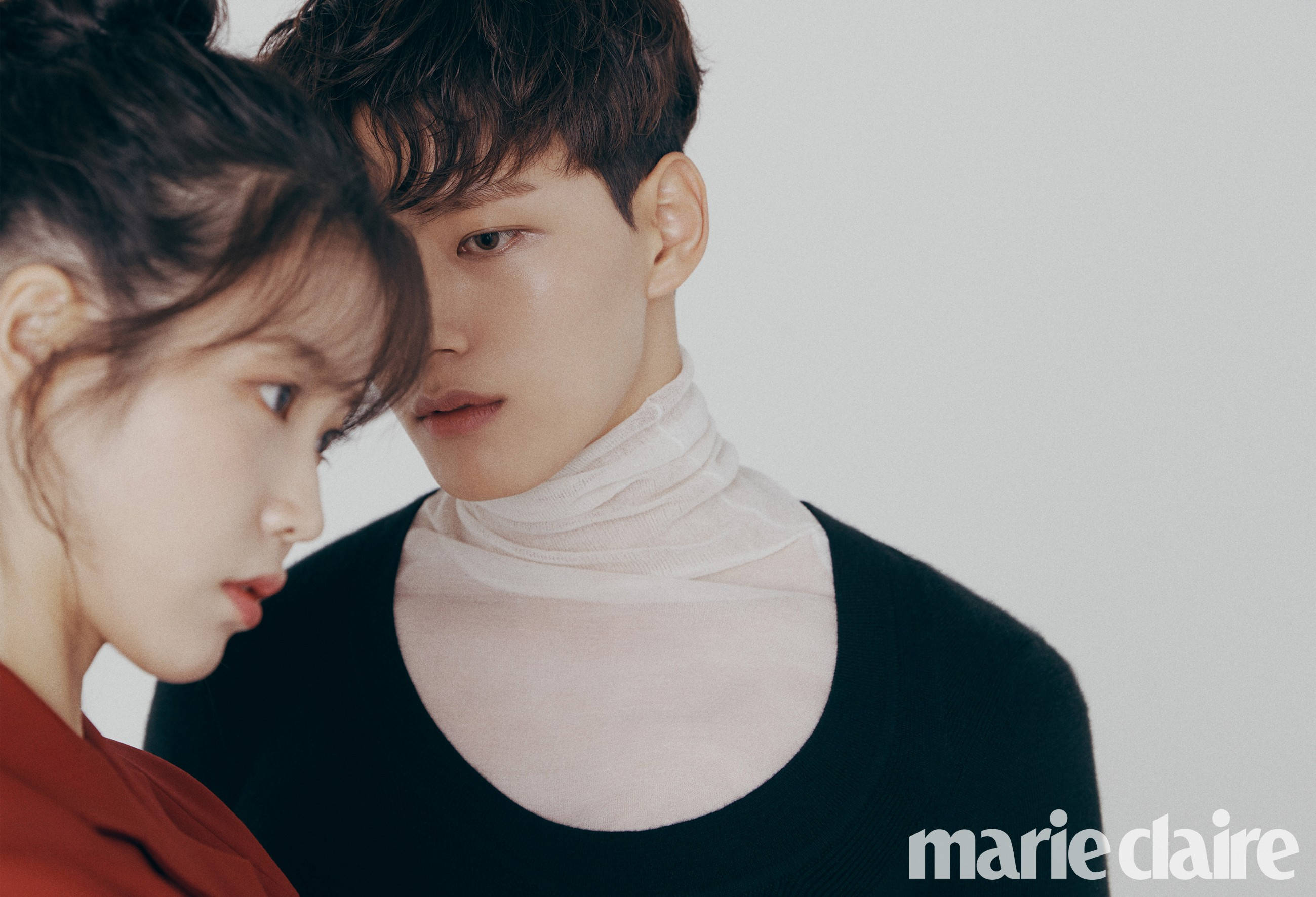 IU 與 Yeo Jin Goo 合拍《Marie Claire》 壁紙 — 一對年輕情侶在純白背景和柔和燈光下親密依偎。
