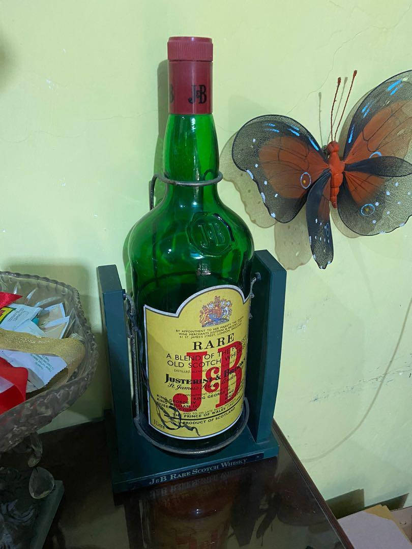 獨特室內家居裝飾 – J&B 巨型威士忌瓶 壁紙 — 一個綠色J&B Rare蘇格蘭威士忌酒瓶放在藍色底座上，置於木桌上，旁邊有裝飾性蝴蝶牆藝。