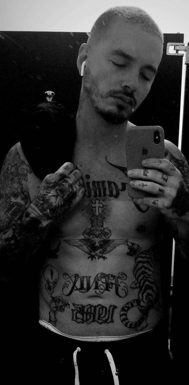 J Balvin 身體紋身 壁紙 — 一個紋身男人閉上眼睛，以黑白方式拍攝鏡子自拍，展現出複雜的胸部紋身和耳機。