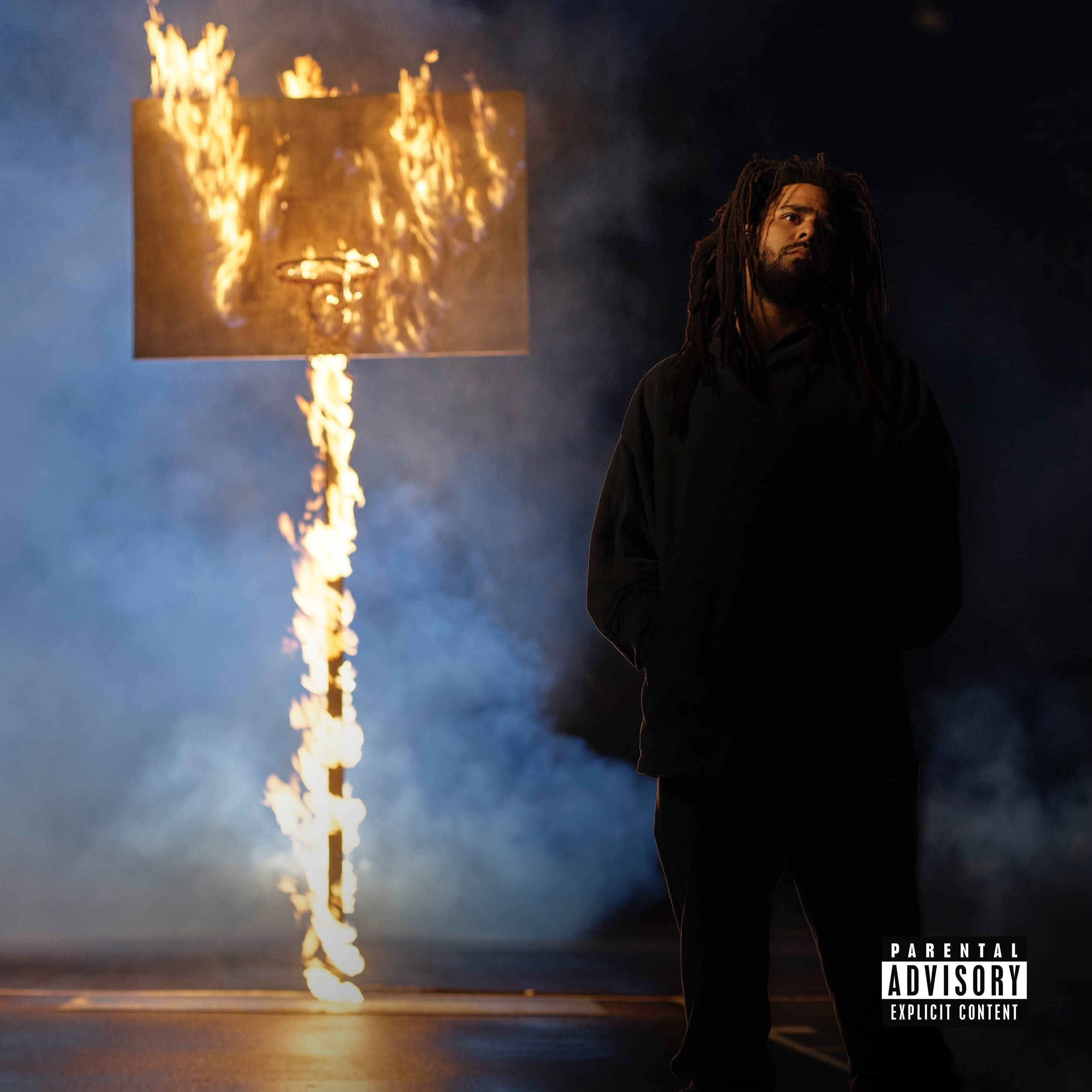 J Cole《The Off-Season》專輯封面 壁紙 — 一個留著辮子頭的男人站在陰影中，旁邊是一個在煙霧繚繞的夜空下發光的燃燒籃球框。