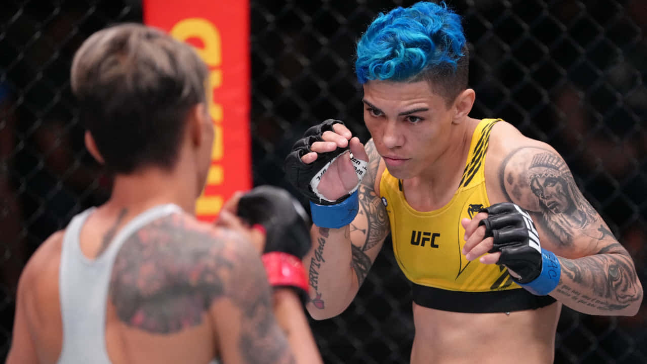 藍髮紋身女MMA拳手在籠中面對對手。