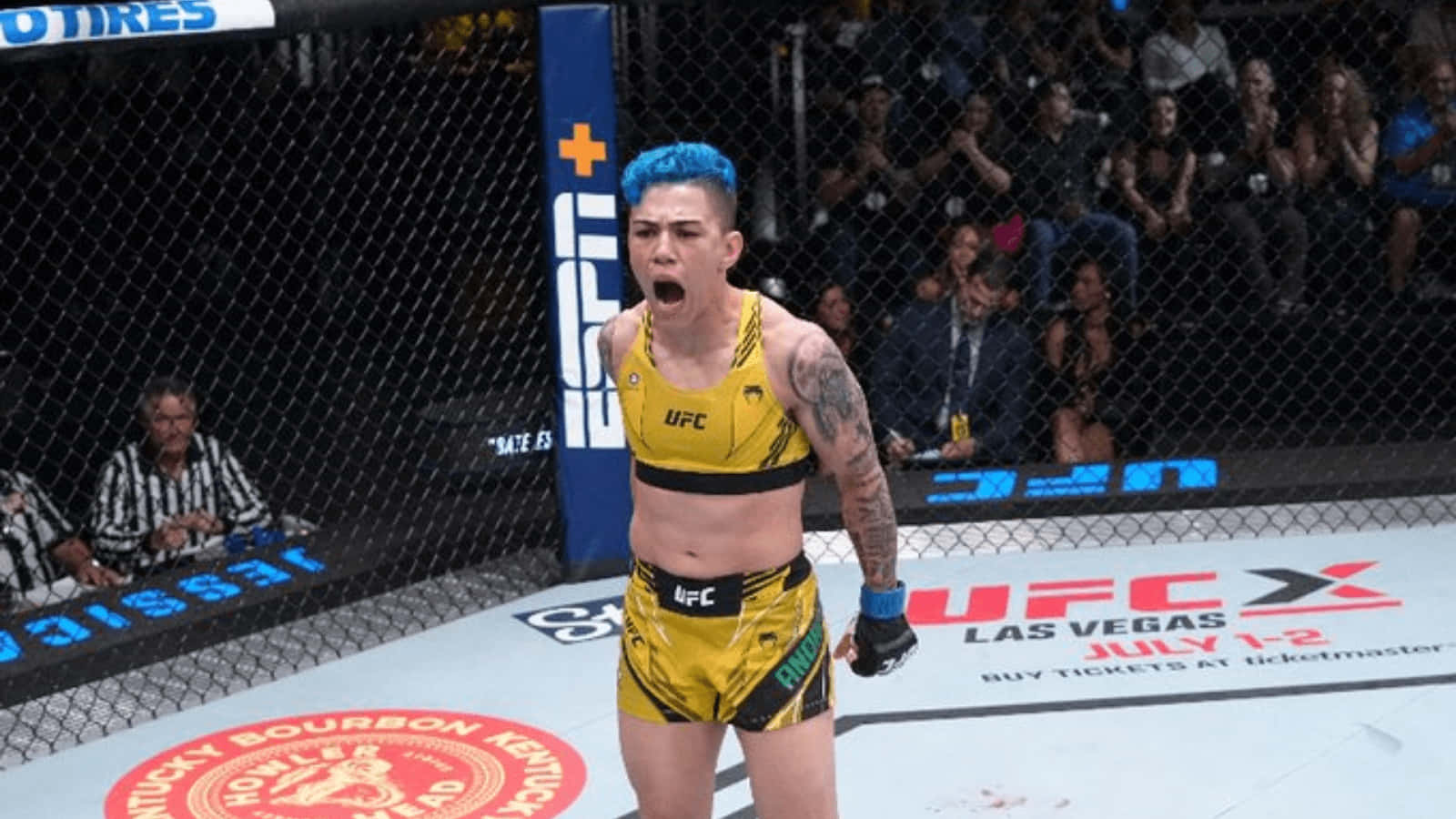 女性MMA拳手在UFC八角籠中以藍色頭髮和黃色裝備慶祝勝利。