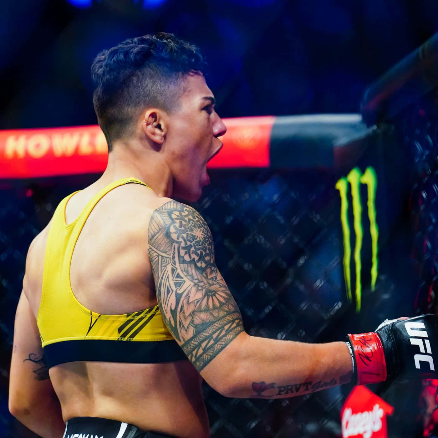 一位男性MMA戰士身穿黃色裝備，在UFC八角籠內慶祝勝利。