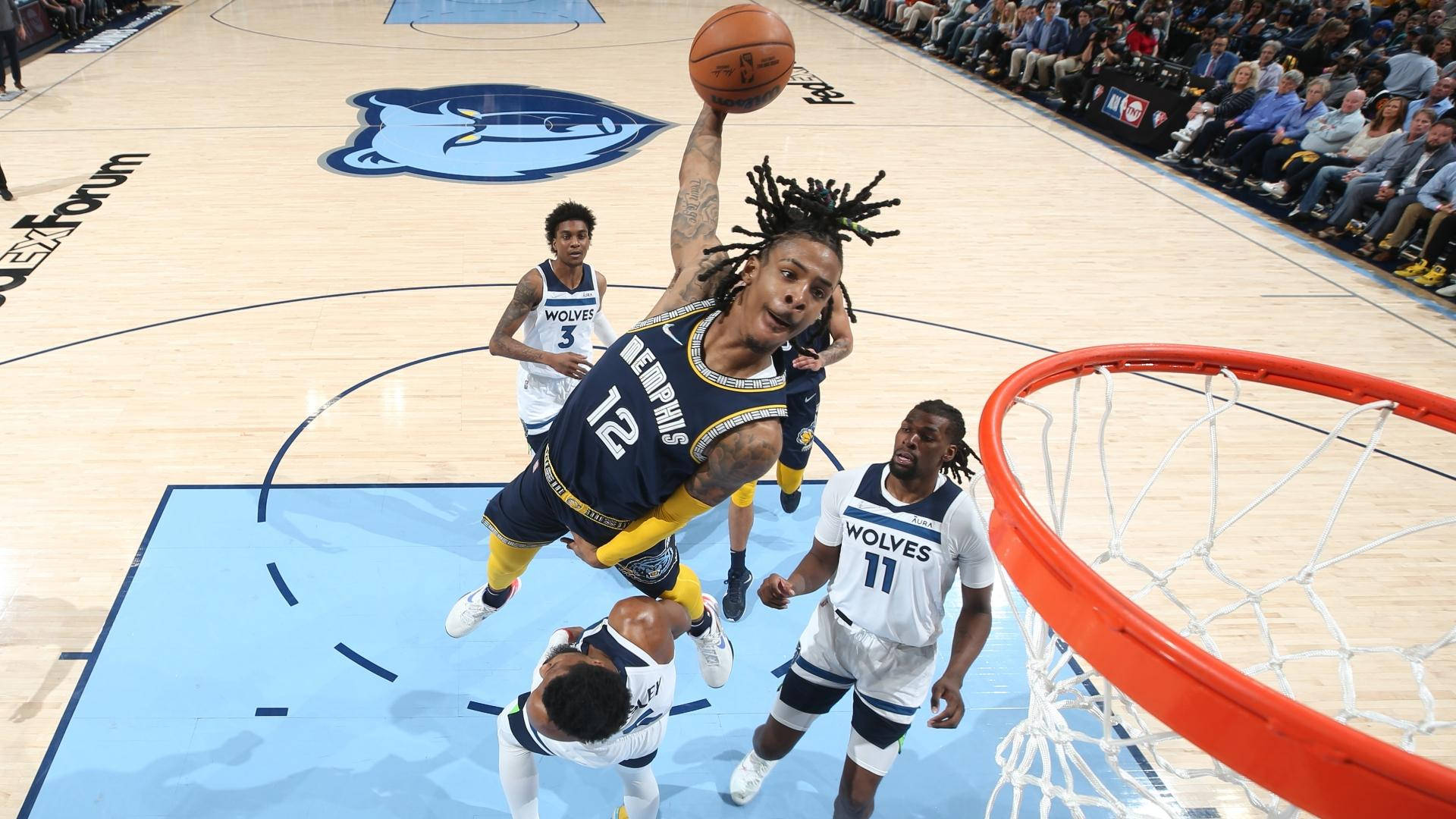Ja Morant 灌籃 對決灰狼隊 壁紙 — 一位孟菲斯灰熊球員在激烈的NBA比賽中，在防守球員附近灌籃。