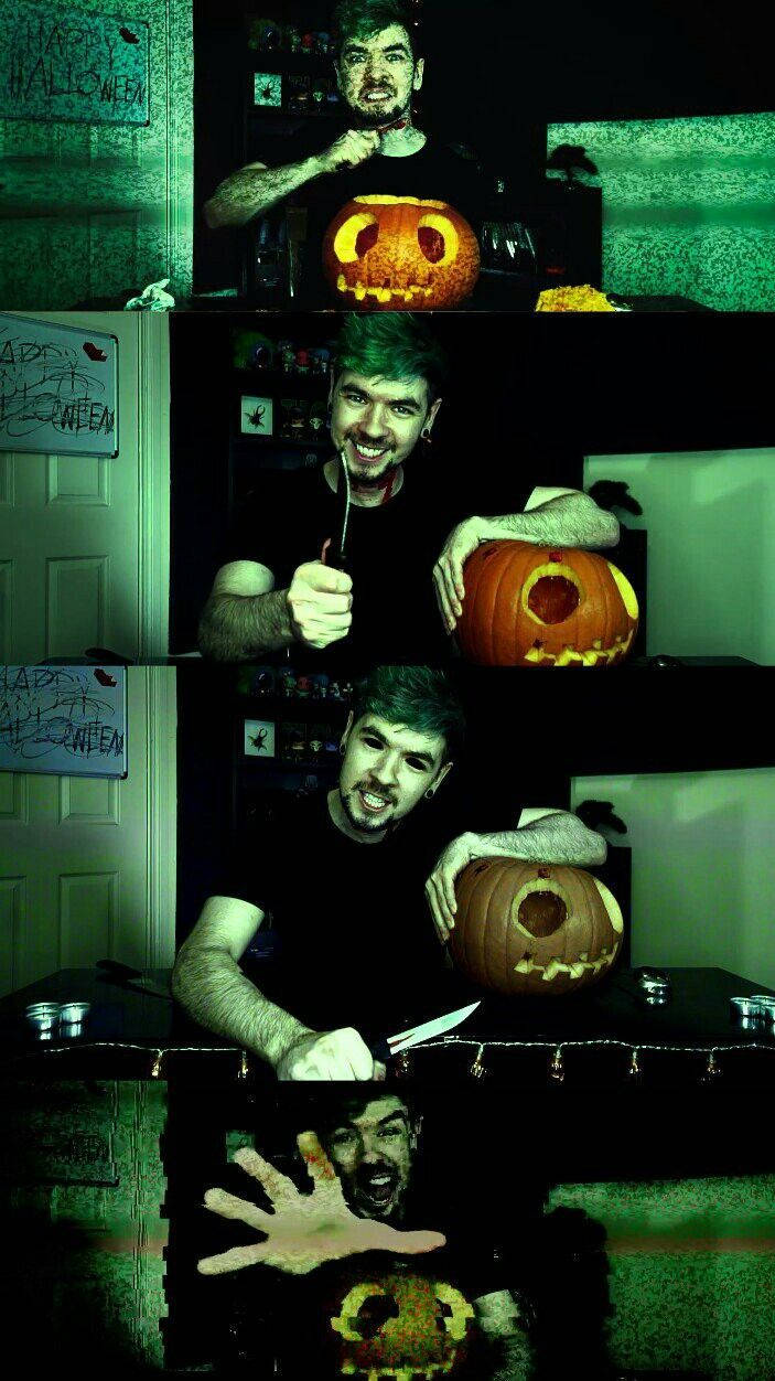 Jacksepticeye萬聖節 壁紙 — 一個綠髮男子在昏暗的房間裏雕刻南瓜，房間有萬聖節裝飾和綠色燈光。