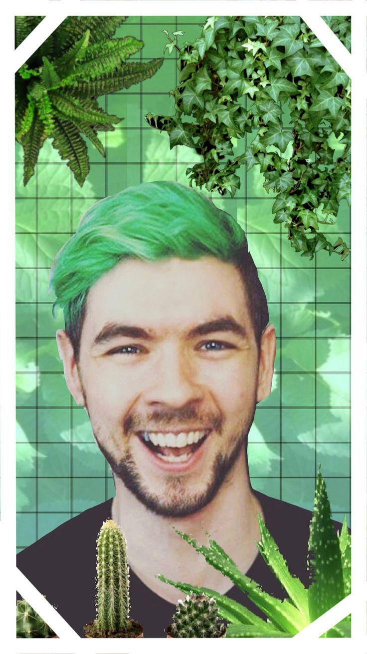 Jacksepticeye 綠色植物主題 壁紙 — 一個微笑的男人，擁有充滿活力的綠色頭髮，被茂密的綠色植物環繞，背景是網格。