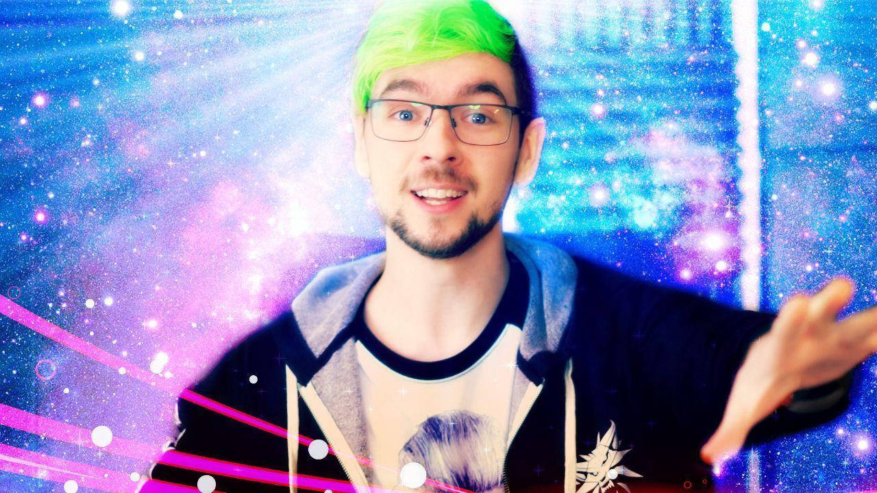 Jacksepticeye星際風 壁紙 — 一名擁有亮綠色頭髮和眼鏡的男子，在帶有發光粉紅色條紋的宇宙銀河背景中微笑。