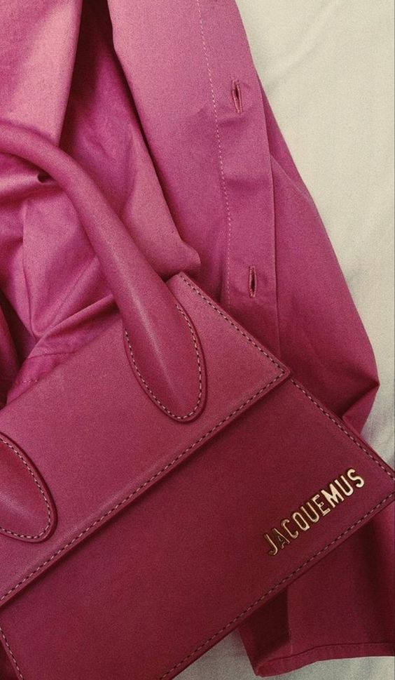 Jacquemus 粉紅 Le Chiquito Nœud 手袋 壁紙 — 一個紫紅色皮革Jacquemus手袋的特寫，放在一件相配的紫紅色衣服上，縫線和品牌標誌清晰可見。