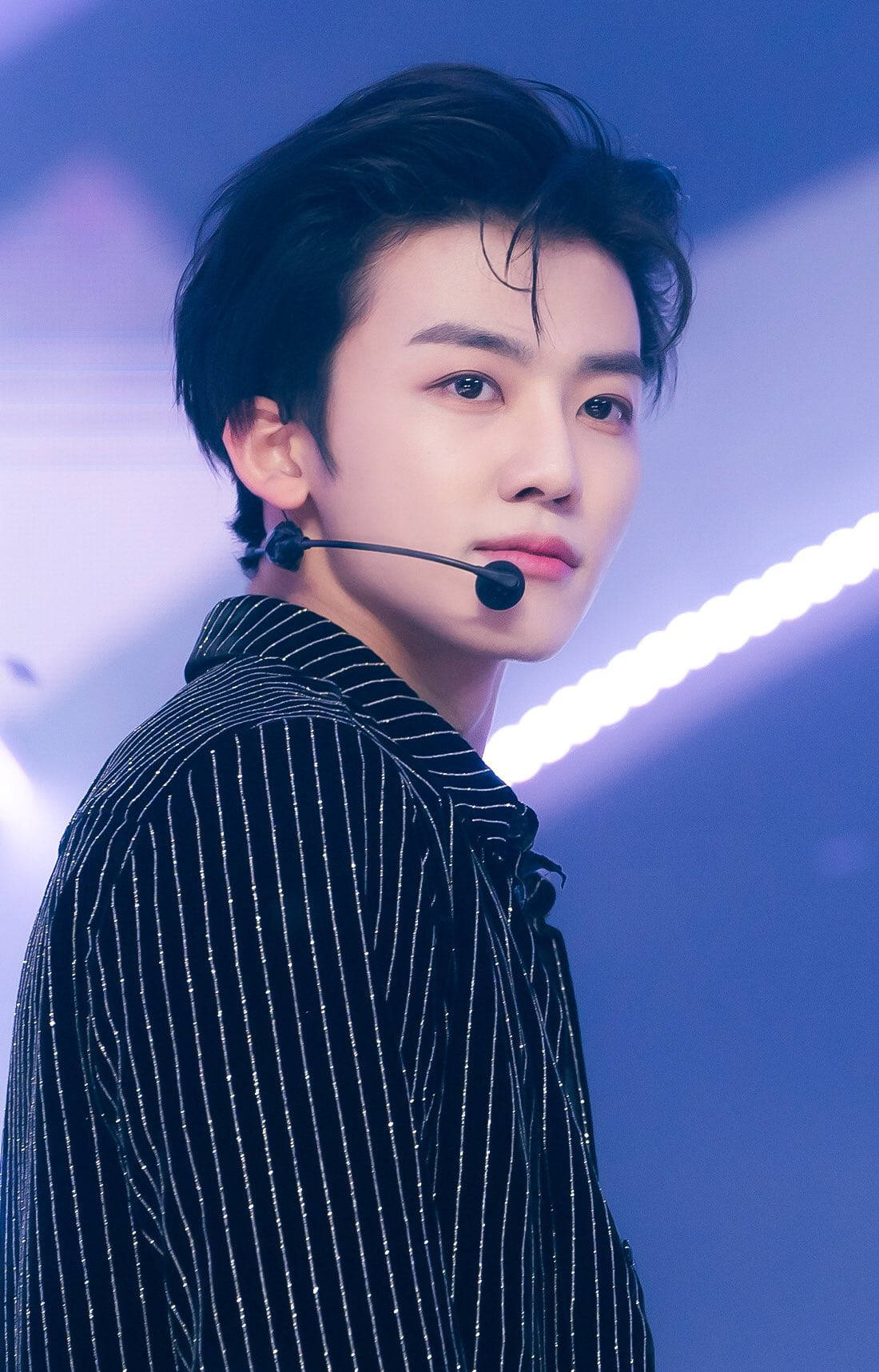Jaemin NCT 條紋襯衫 壁紙 — 一位深色頭髮的年輕男子穿著細條紋外套和耳機，背景是發光的藍色舞台。
