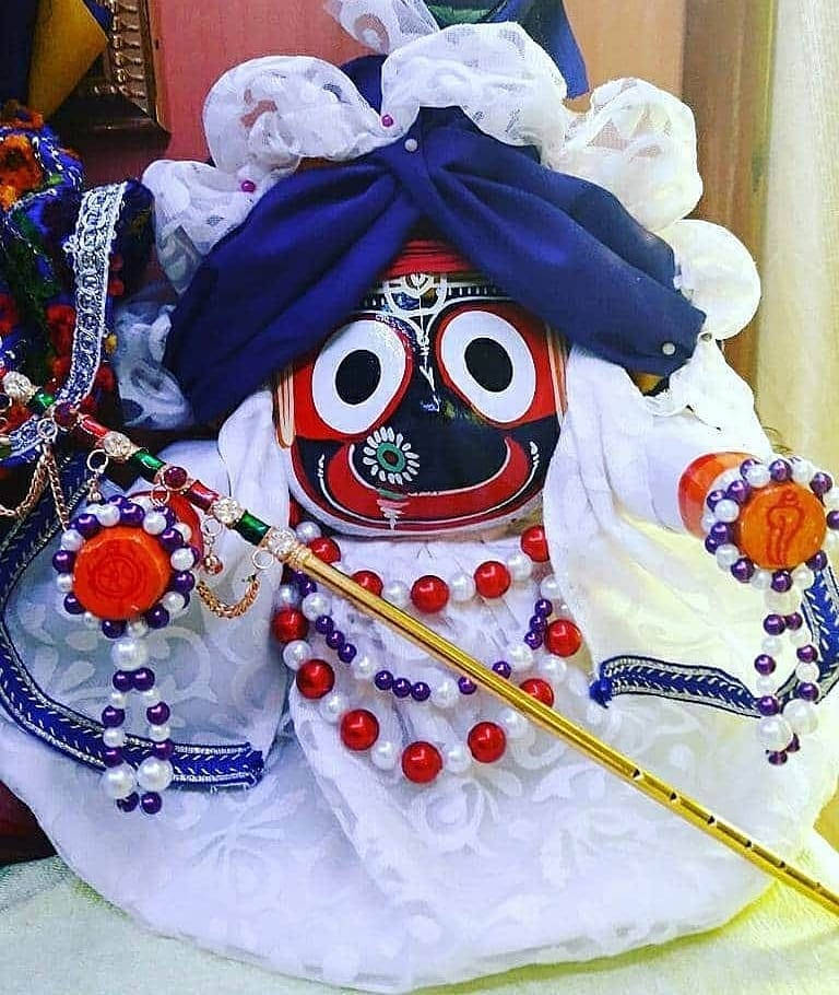 身穿白色服裝的 Jagannath 壁紙 — 一個色彩鮮豔的傳統印度神像，紅臉、白眼、藍色頭巾，飾有華麗珠寶。