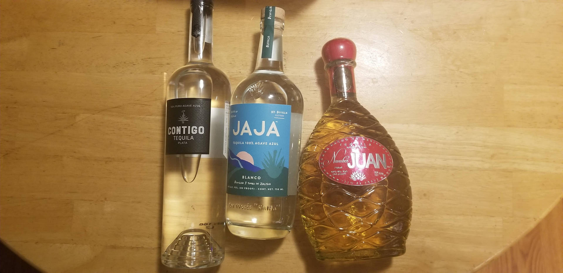 木質表面上的三個龍舌蘭酒瓶