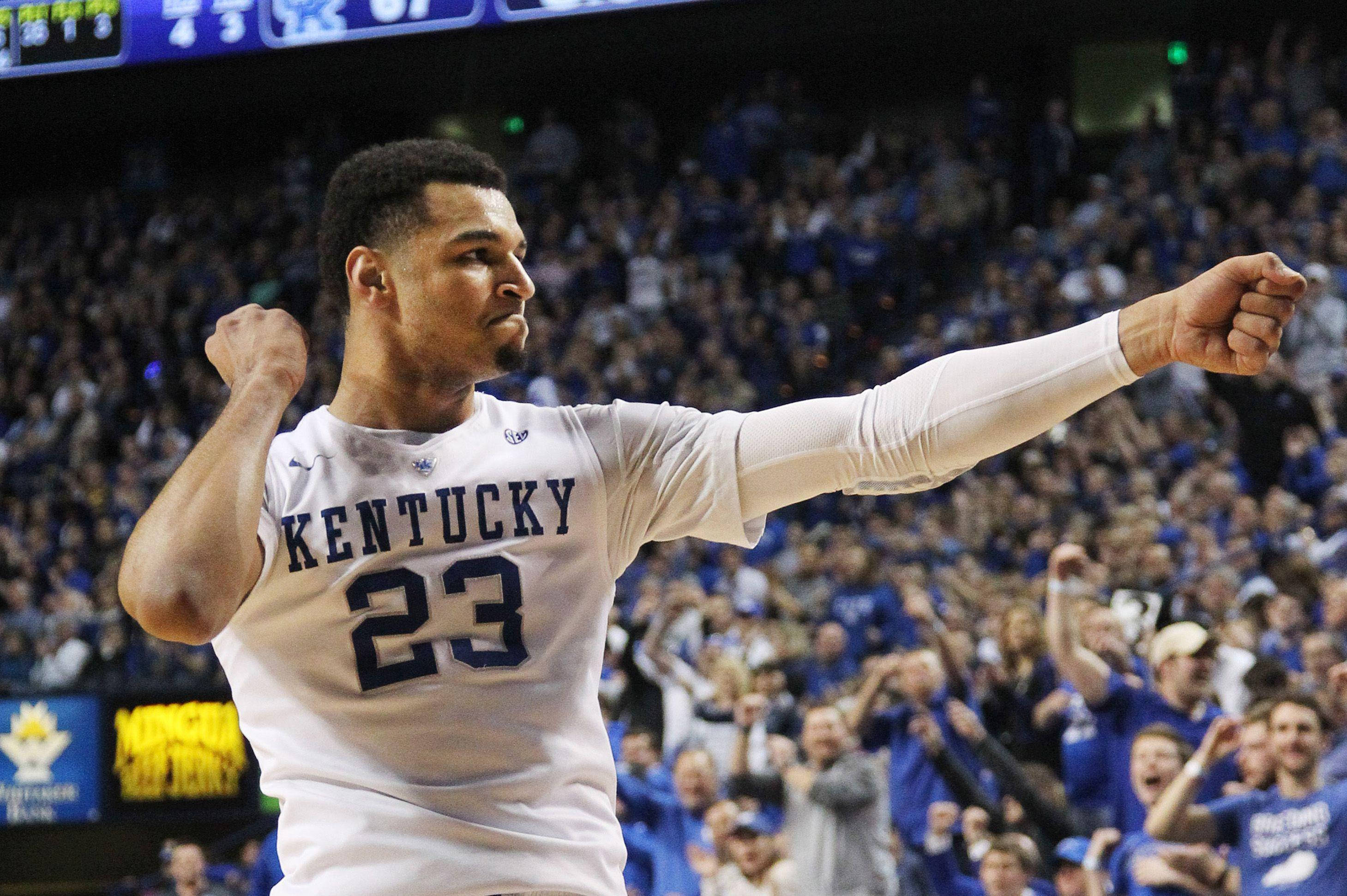Jamal Murray 觀眾互動 壁紙 — 一位身穿23號球衣的肯塔基籃球運動員，在擠滿藍衣球迷的場館中高舉拳頭慶祝勝利。