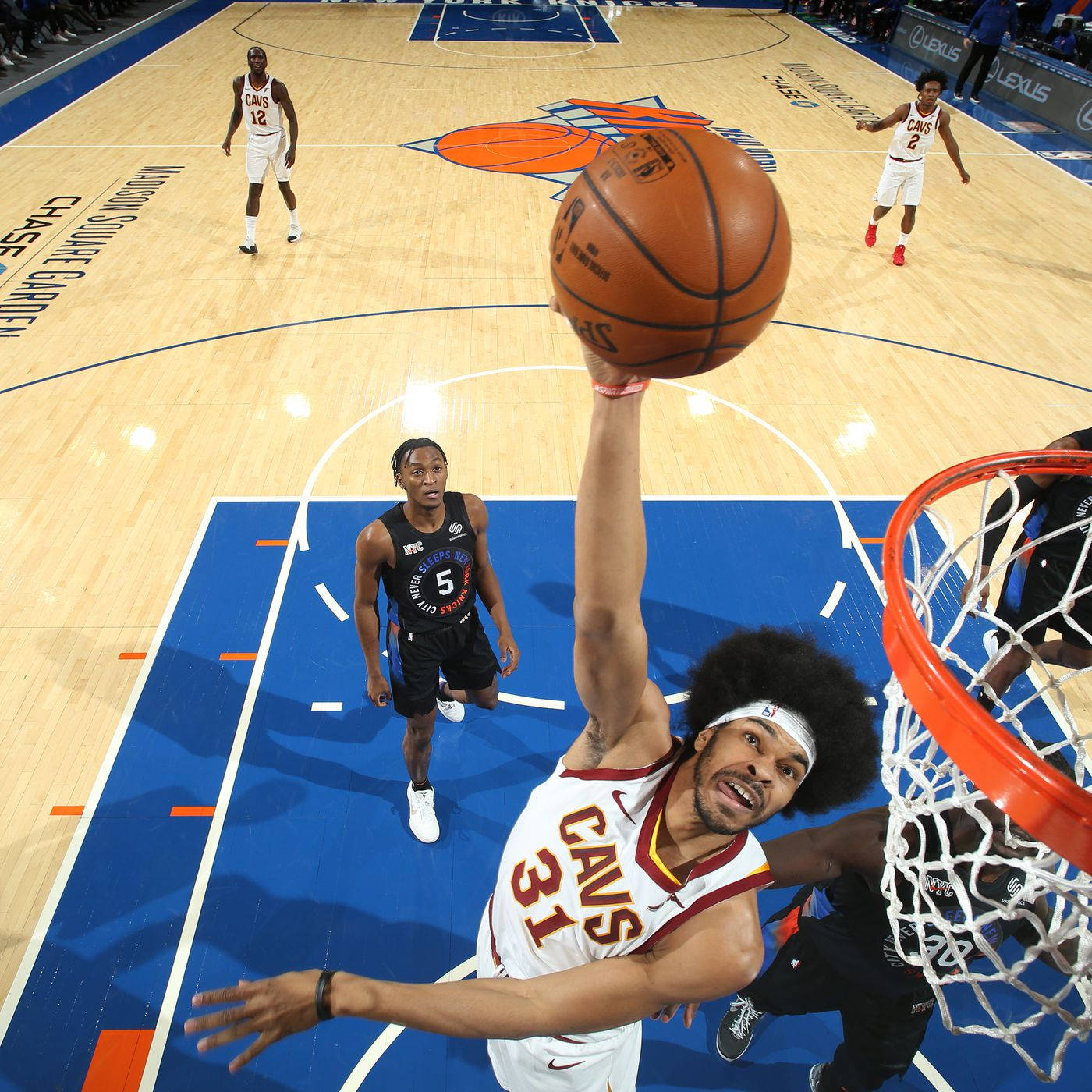 Jarrett Allen 拿下灌籃 壁紙 — 一名身穿白色Cavs球衣的籃球運動員在防守球員從球場觀看時，強力灌籃。