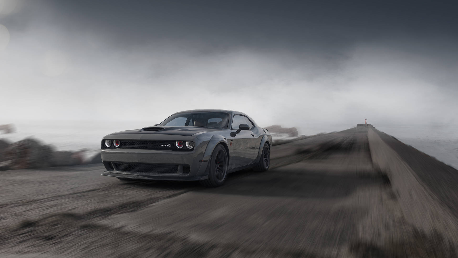 灰色嘅 Dodge Challenger Hellcat 喺有霧嘅天氣下，喺海岸公路上高速行駛。