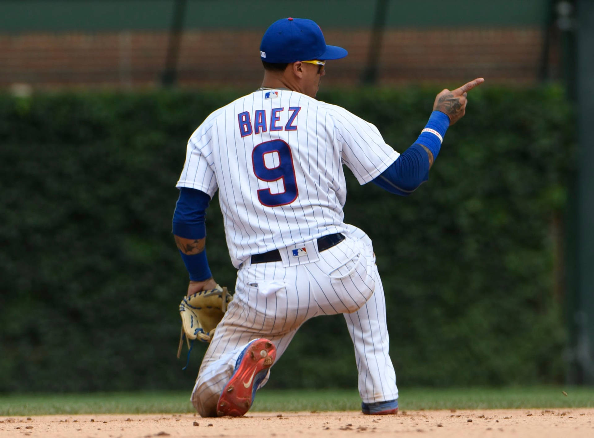 棒球手 Javier Baez 在晴朗的日子比賽中指向。