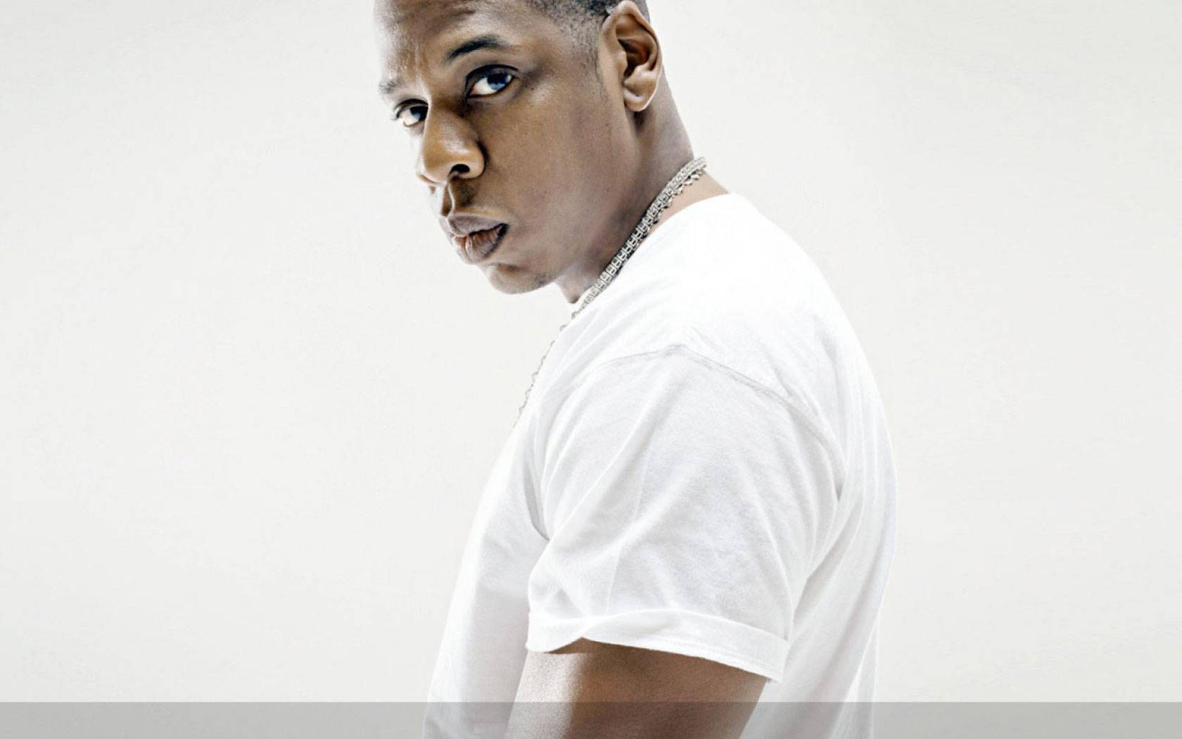 Jay-Z 白色襯衫 壁紙 — 一個穿著白色T恤的男人轉頭直視相機，背景是純白色。