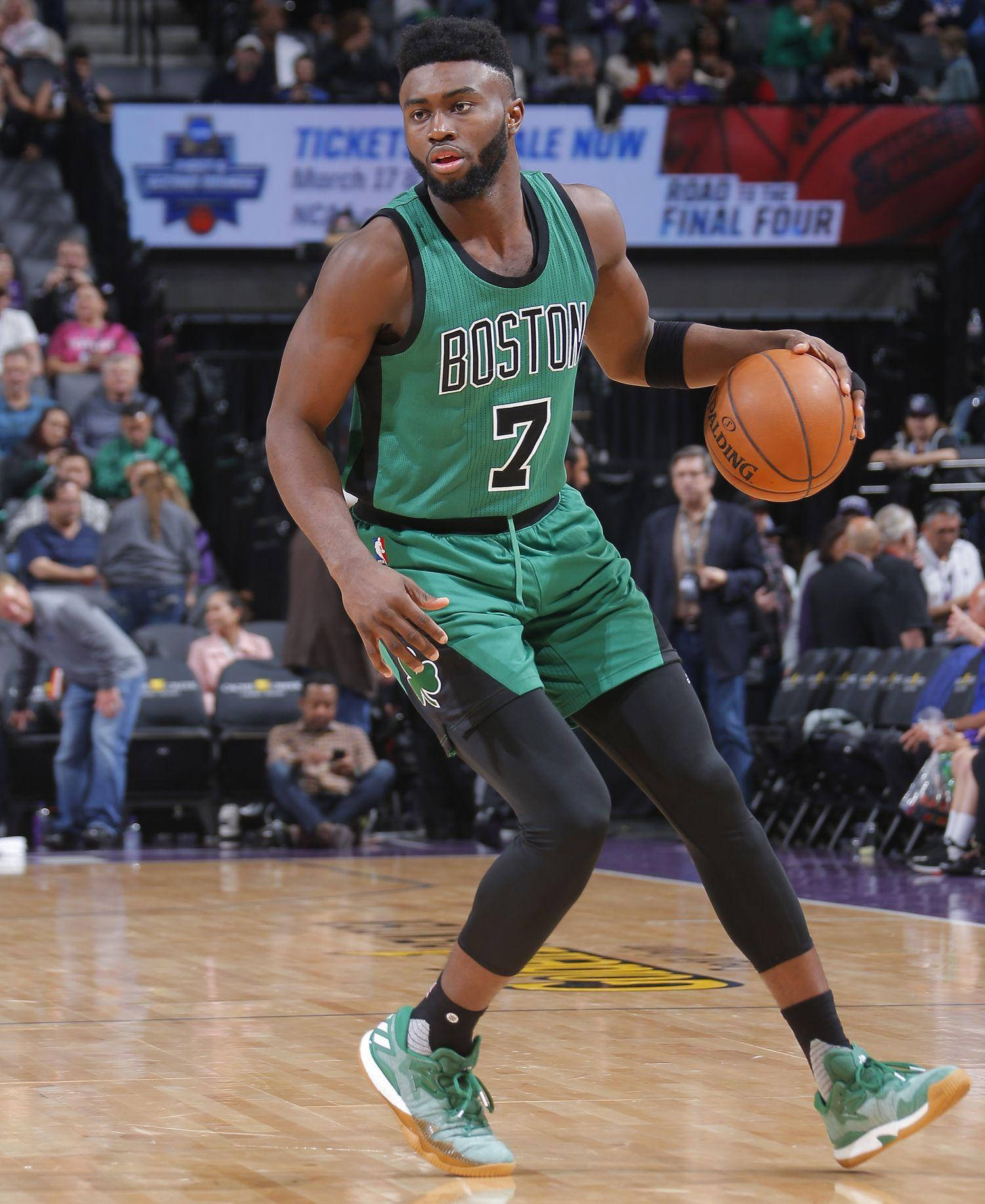 Jaylen Brown 波士頓球員戰術姿勢 壁紙 — 一位身穿綠色球衣的波士頓塞爾特人籃球運動員在激烈的比賽中運球，背景有觀眾。