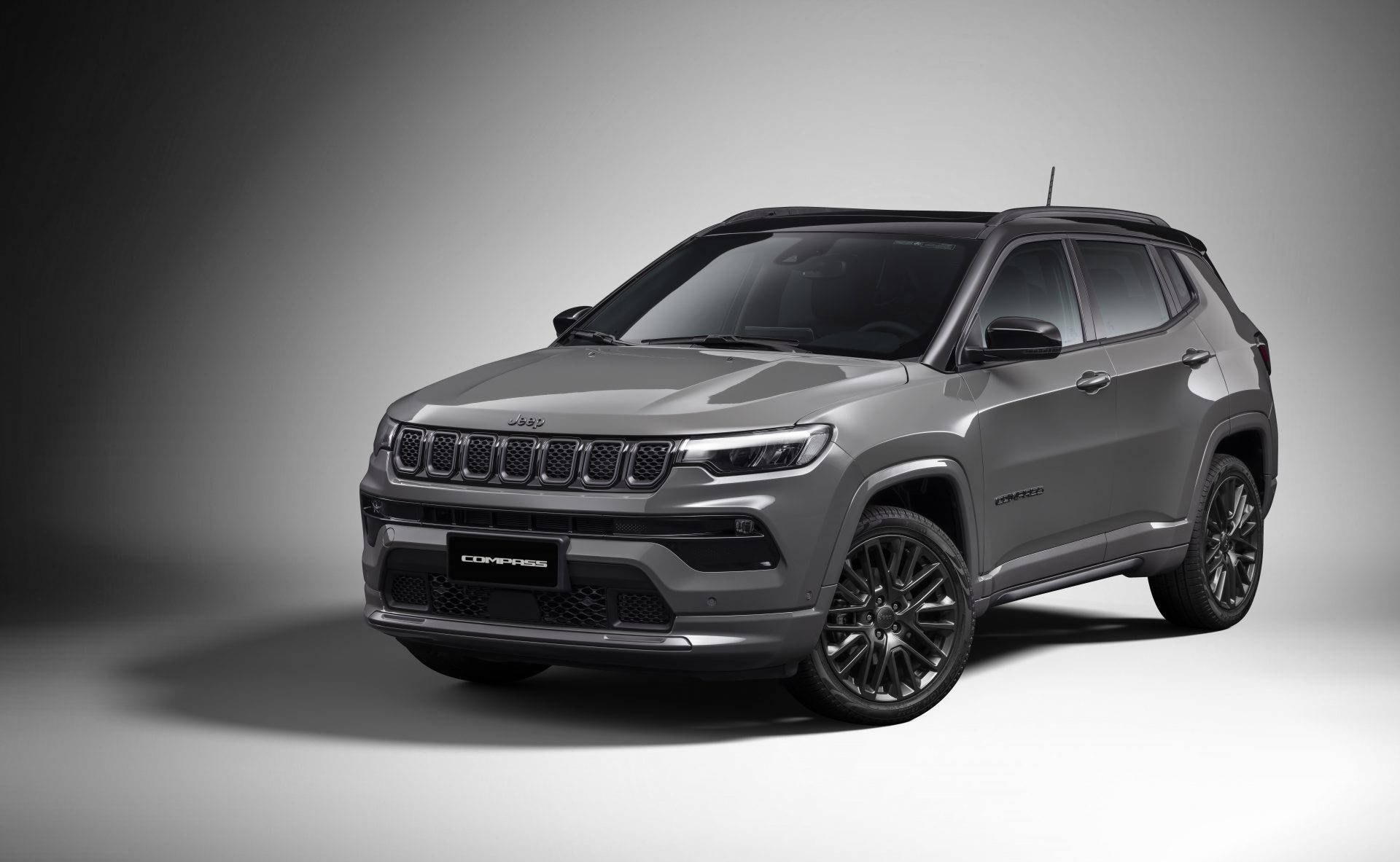 釋放你的冒險精神，盡顯迷人黑色Jeep Compass 壁紙 — 在極簡風格工作室中，以柔和燈光和漸變背景展示的時尚灰色Jeep Compass SUV。